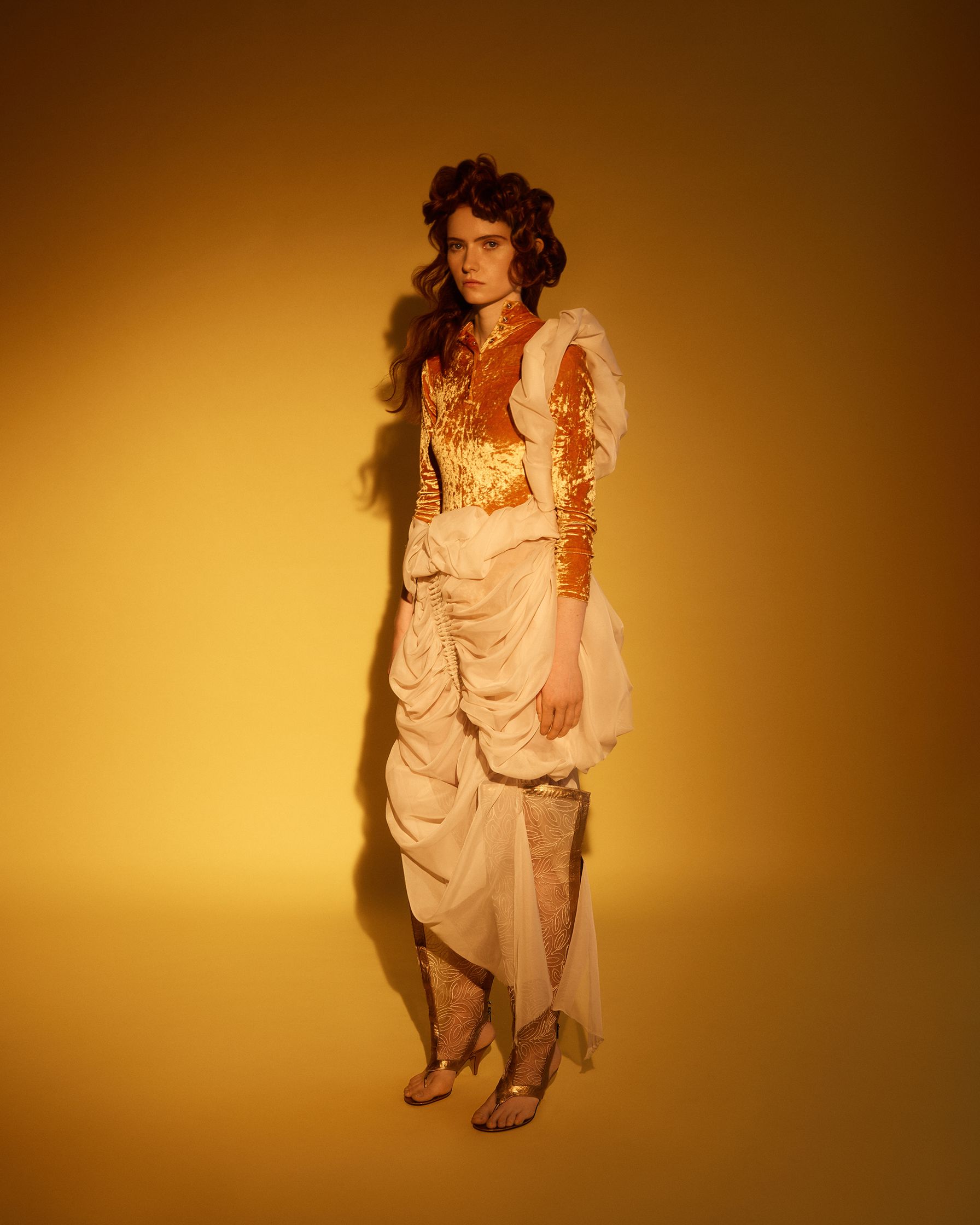 a woman in a dress posing against a yellow background