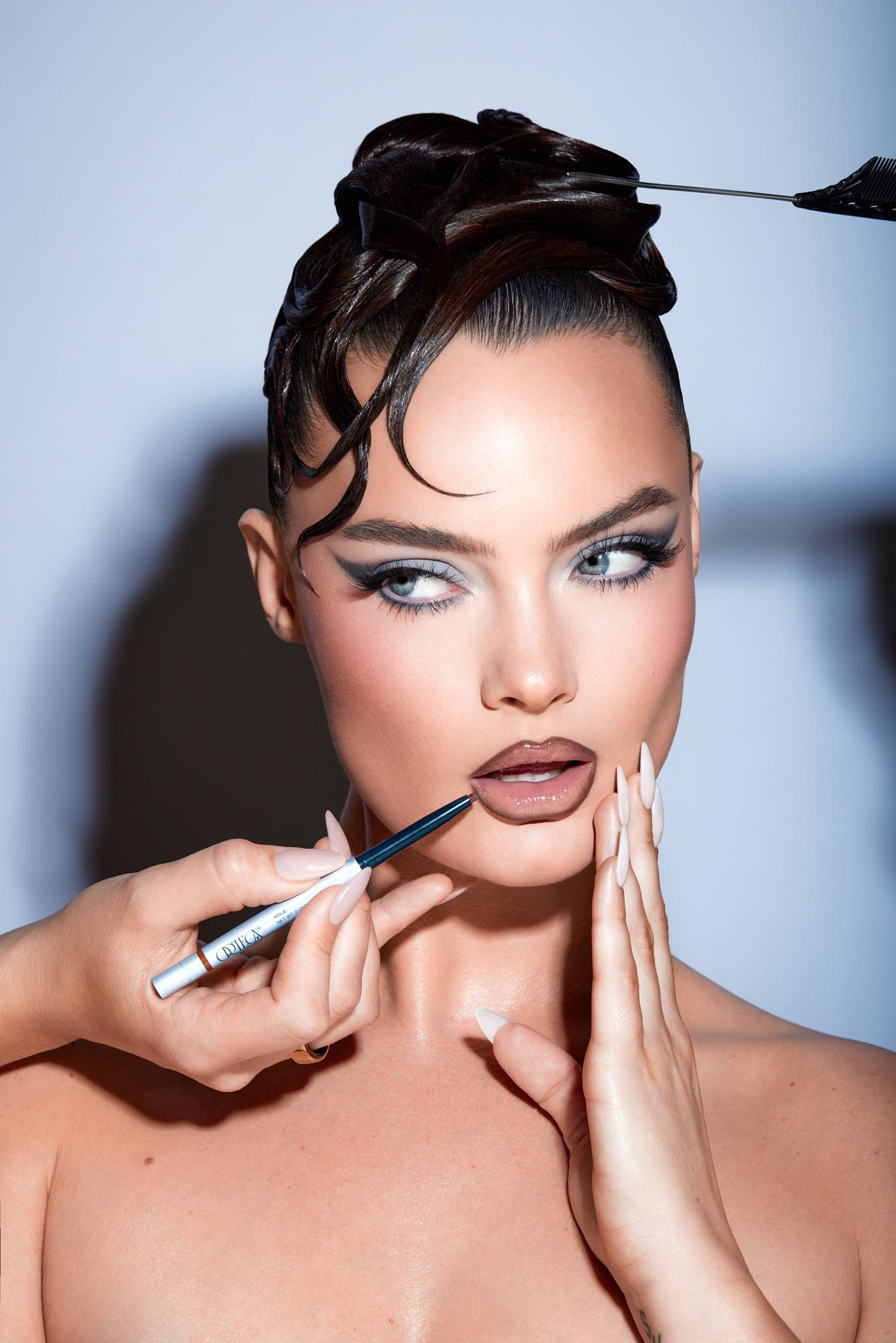 a woman is getting her makeup done by a makeup artist