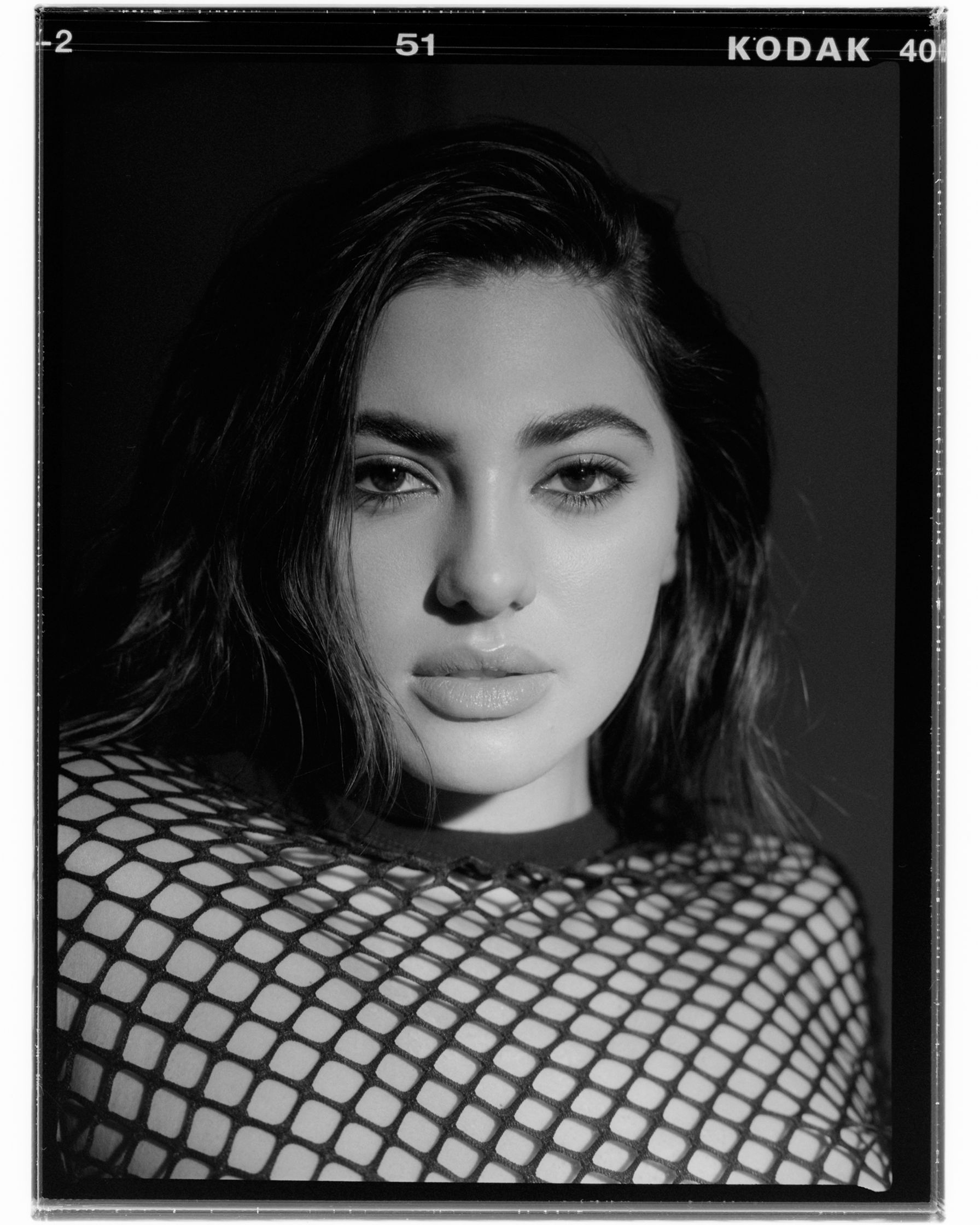 a black and white photo of a woman in a fishnet top