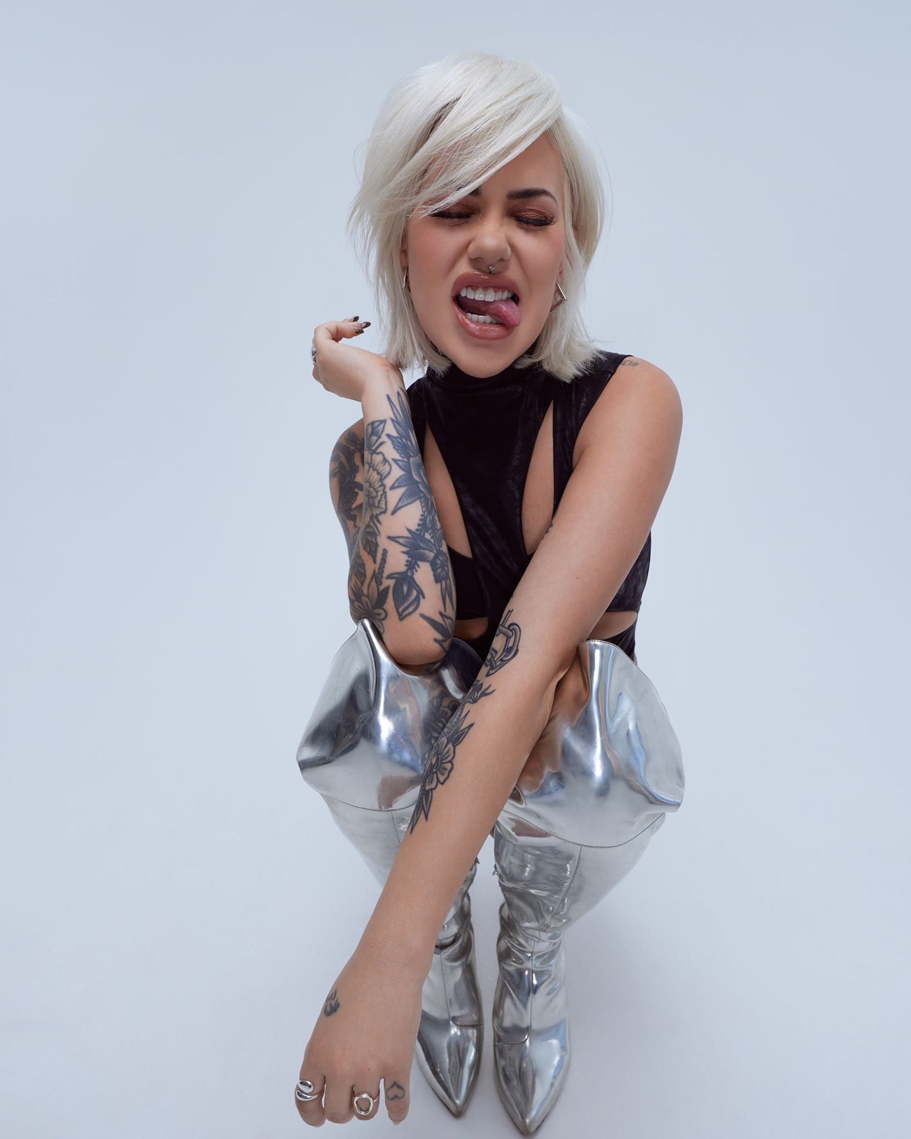 a woman with tattoos posing on a white background