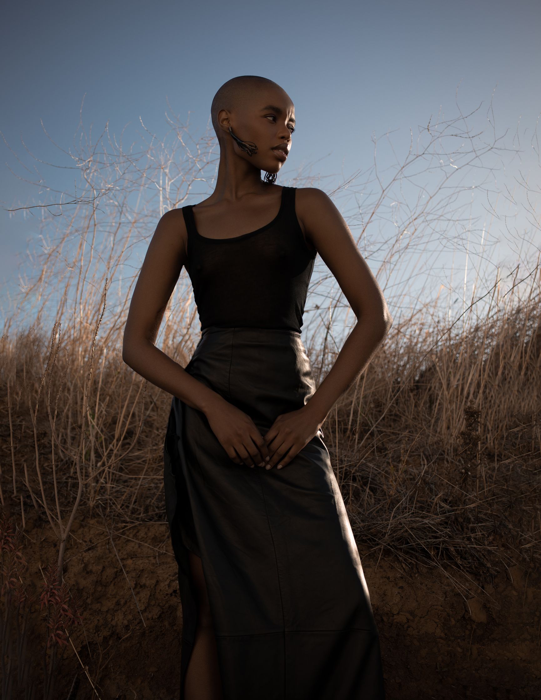 a woman in a black skirt standing in a field