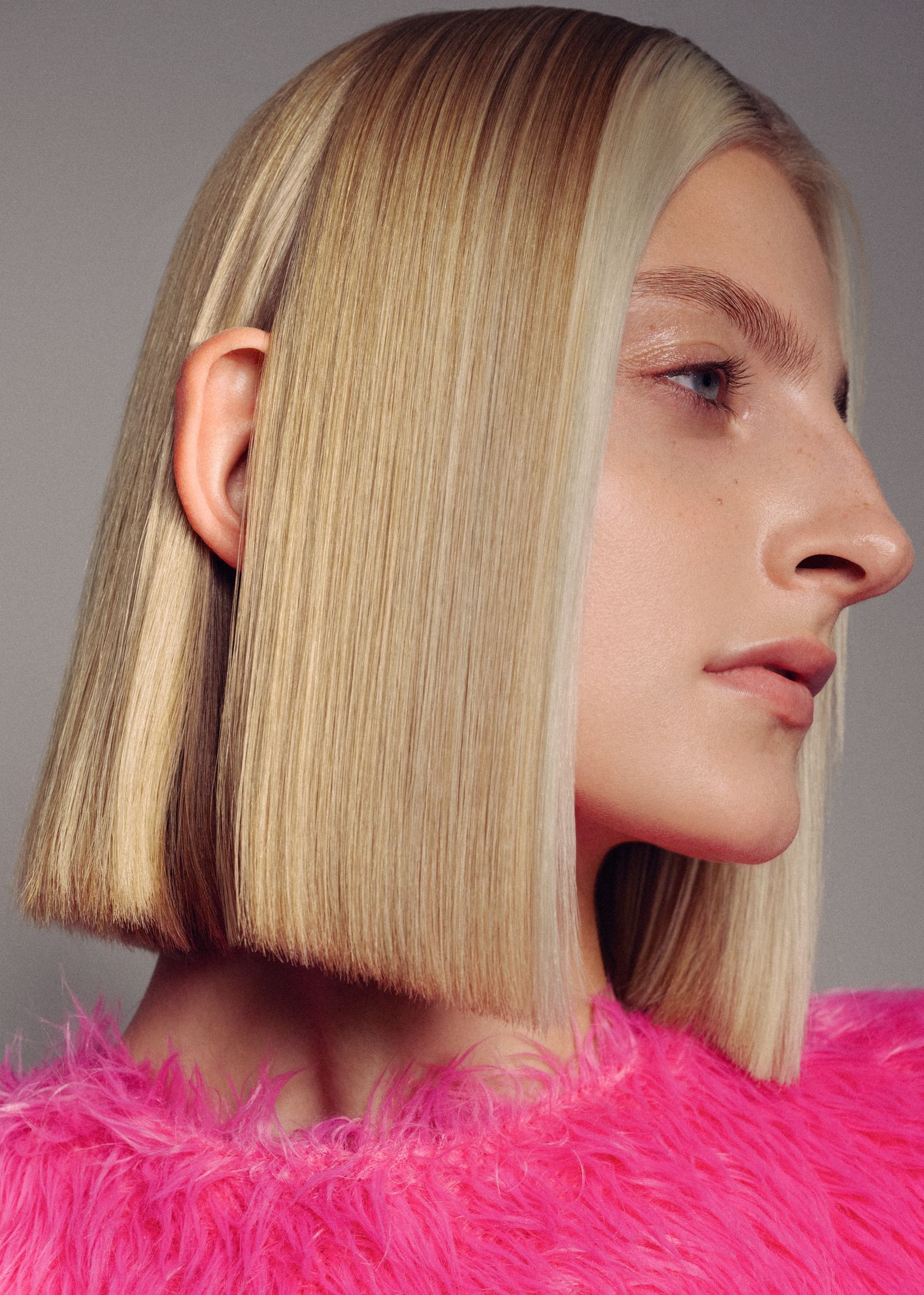 a woman wearing a pink fur coat and a blonde bob