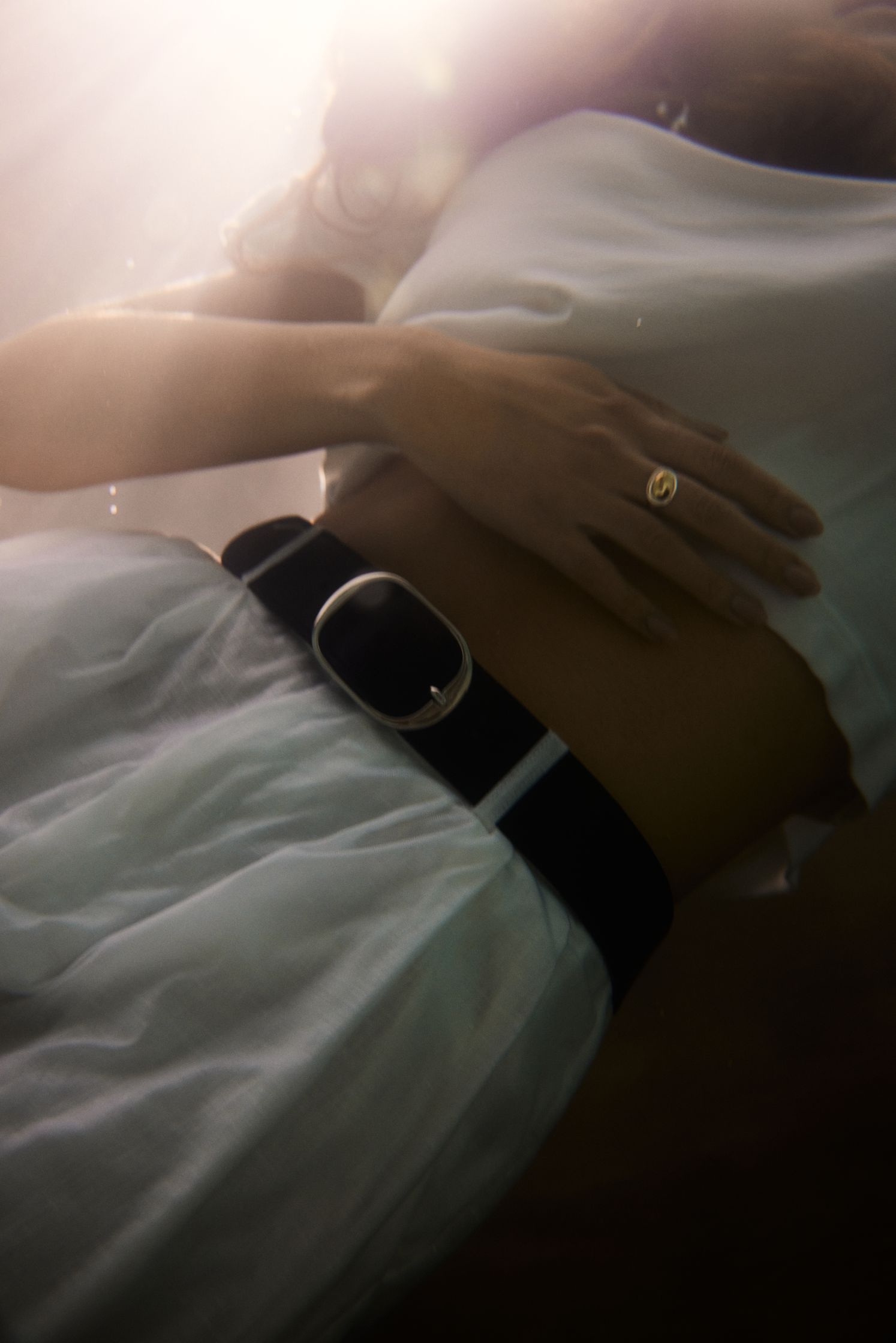 a woman wearing a white dress and a black belt