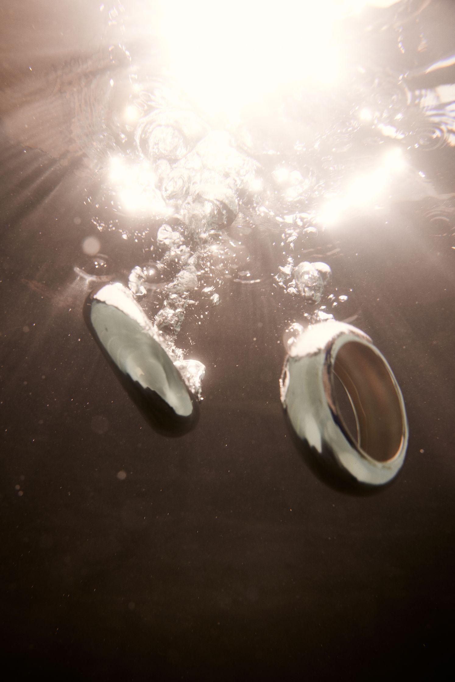two silver rings floating in the water