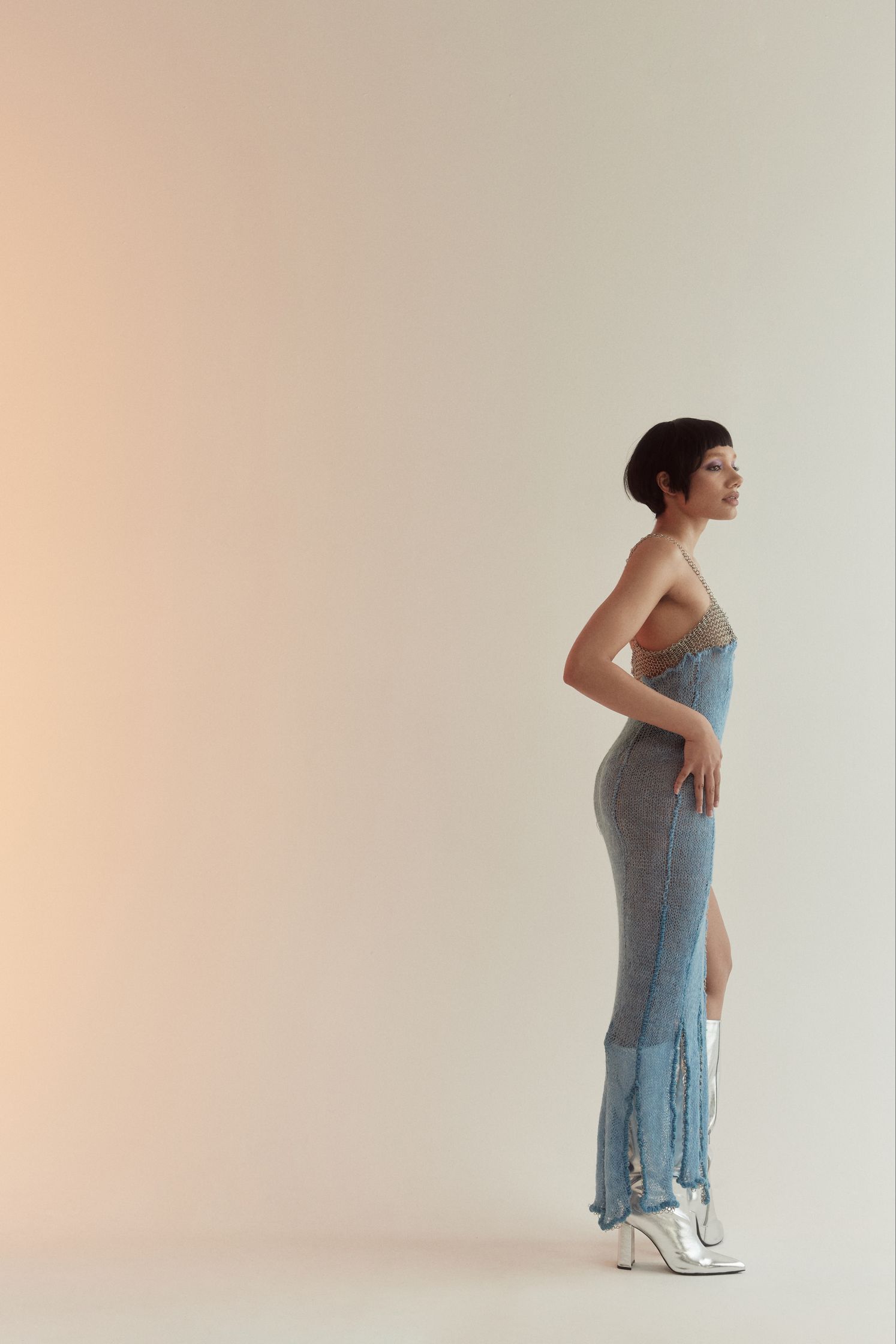 a woman in a blue dress standing in front of a white background