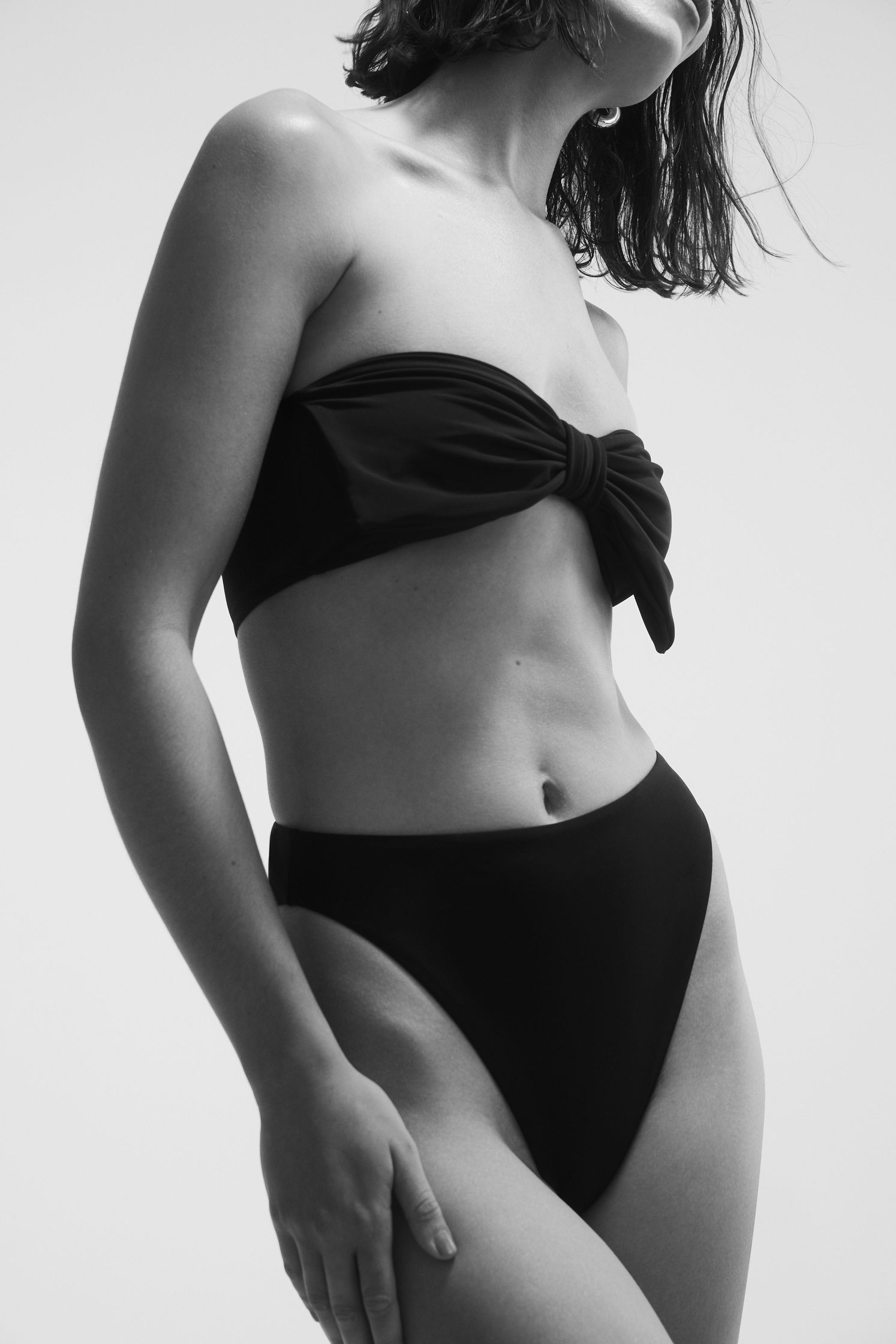 a woman in a black bikini posing for a photo