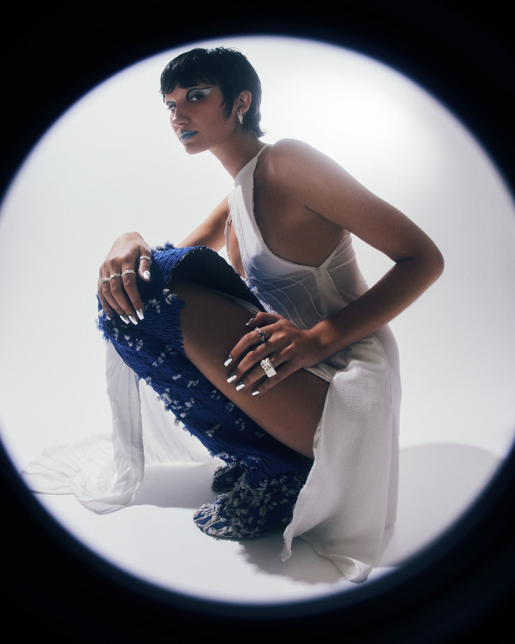 a woman in a white dress is posing in front of a mirror