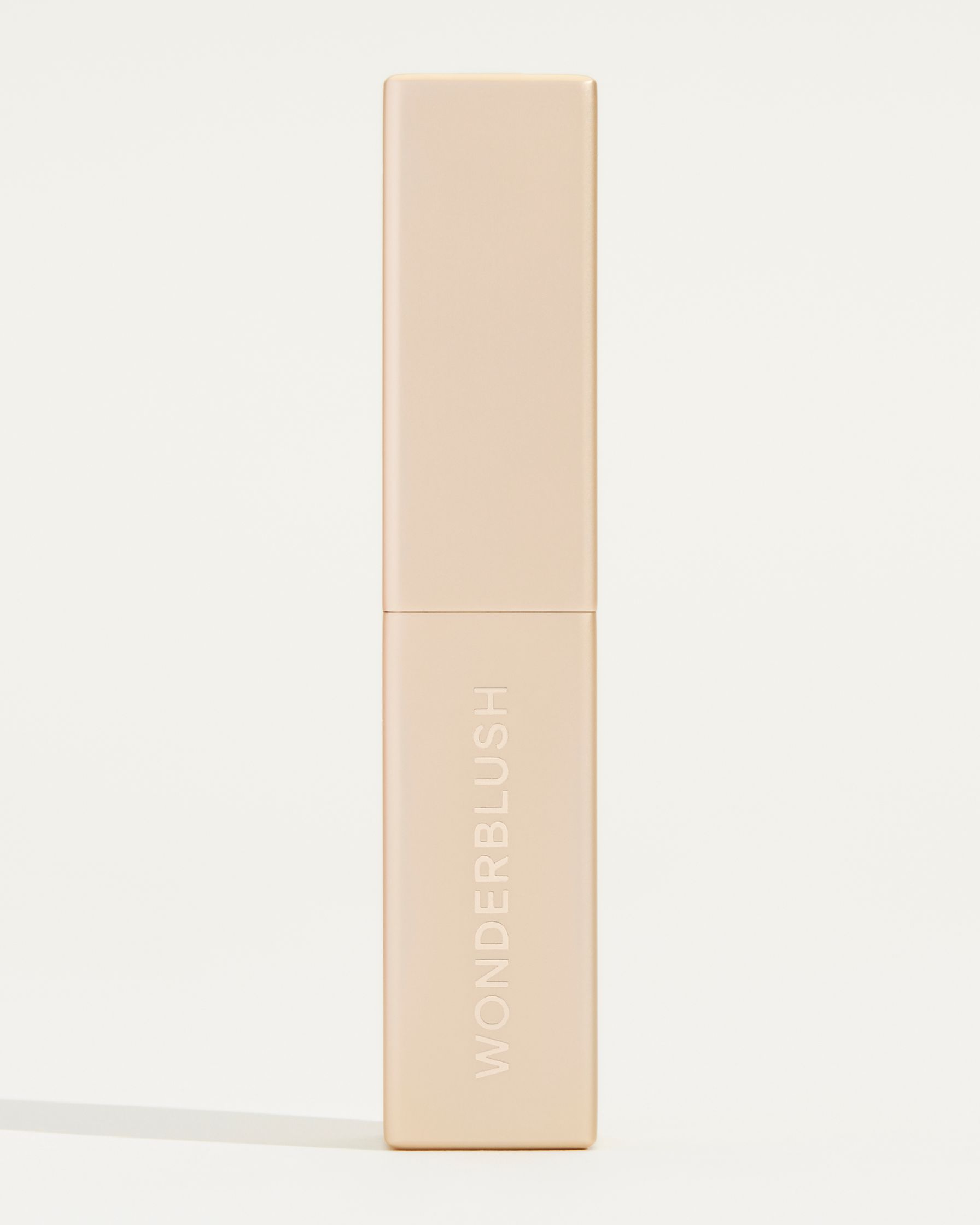 a tube of beige lipstick on a white background