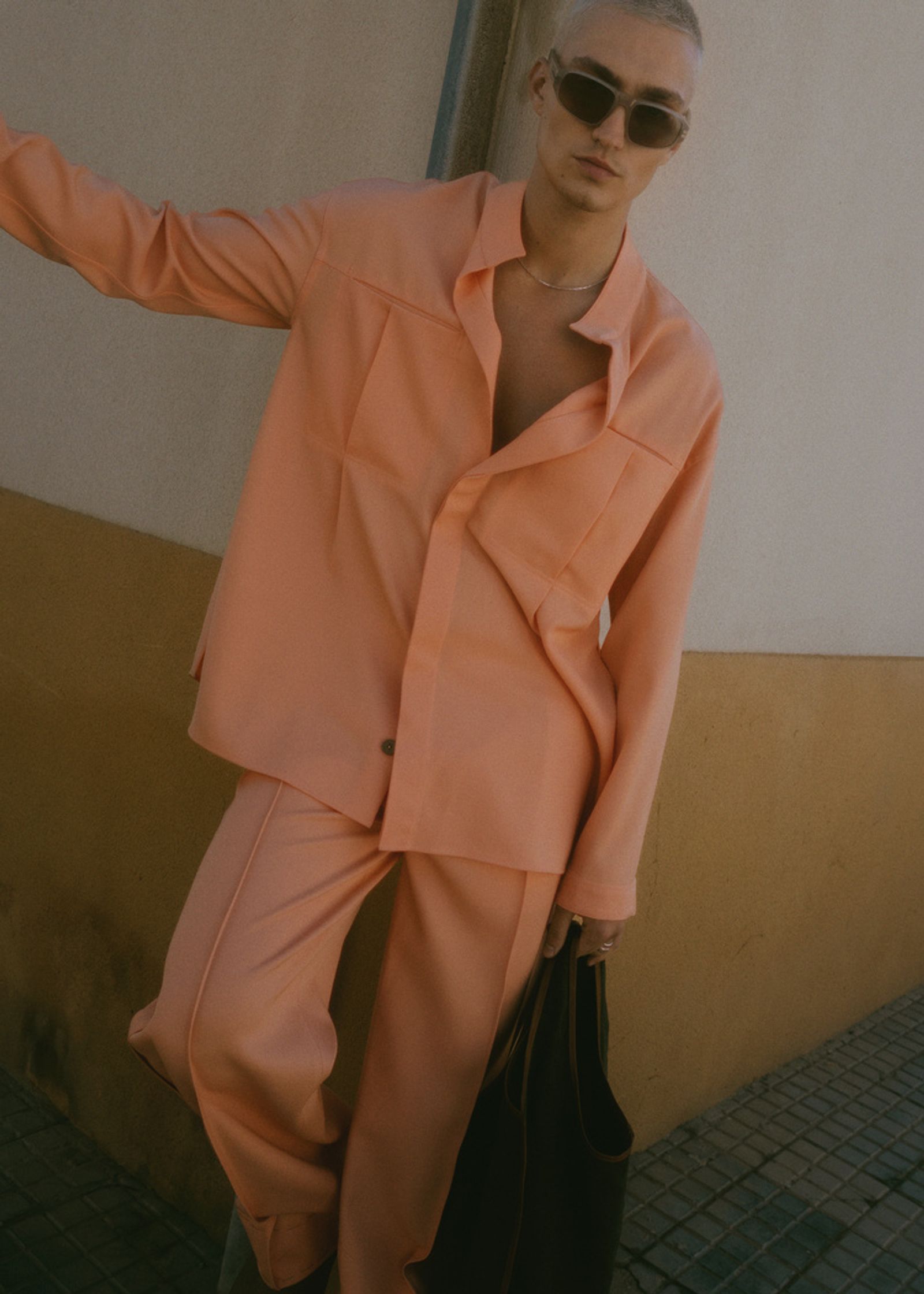 a woman wearing an orange suit and sunglasses