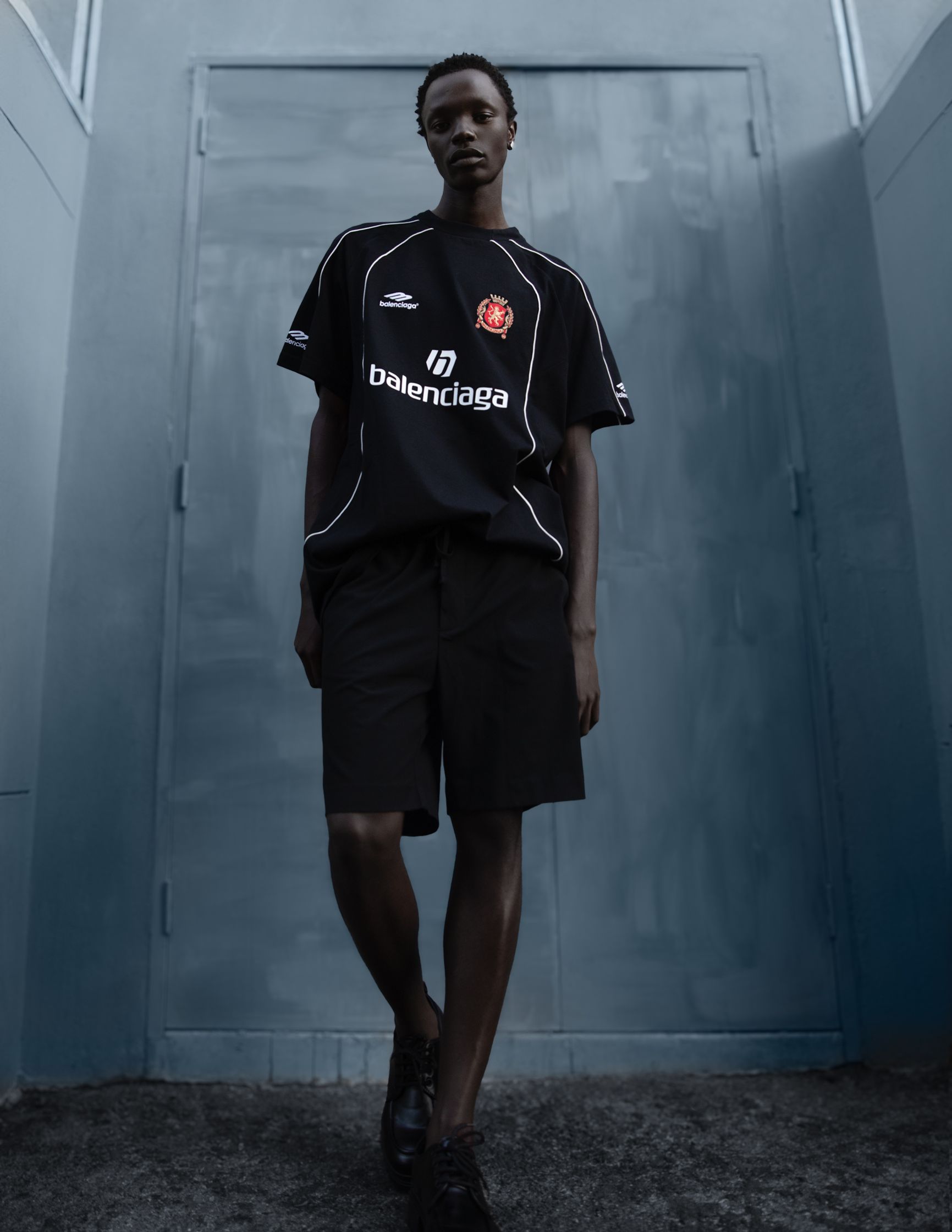 a man wearing a black t - shirt and shorts