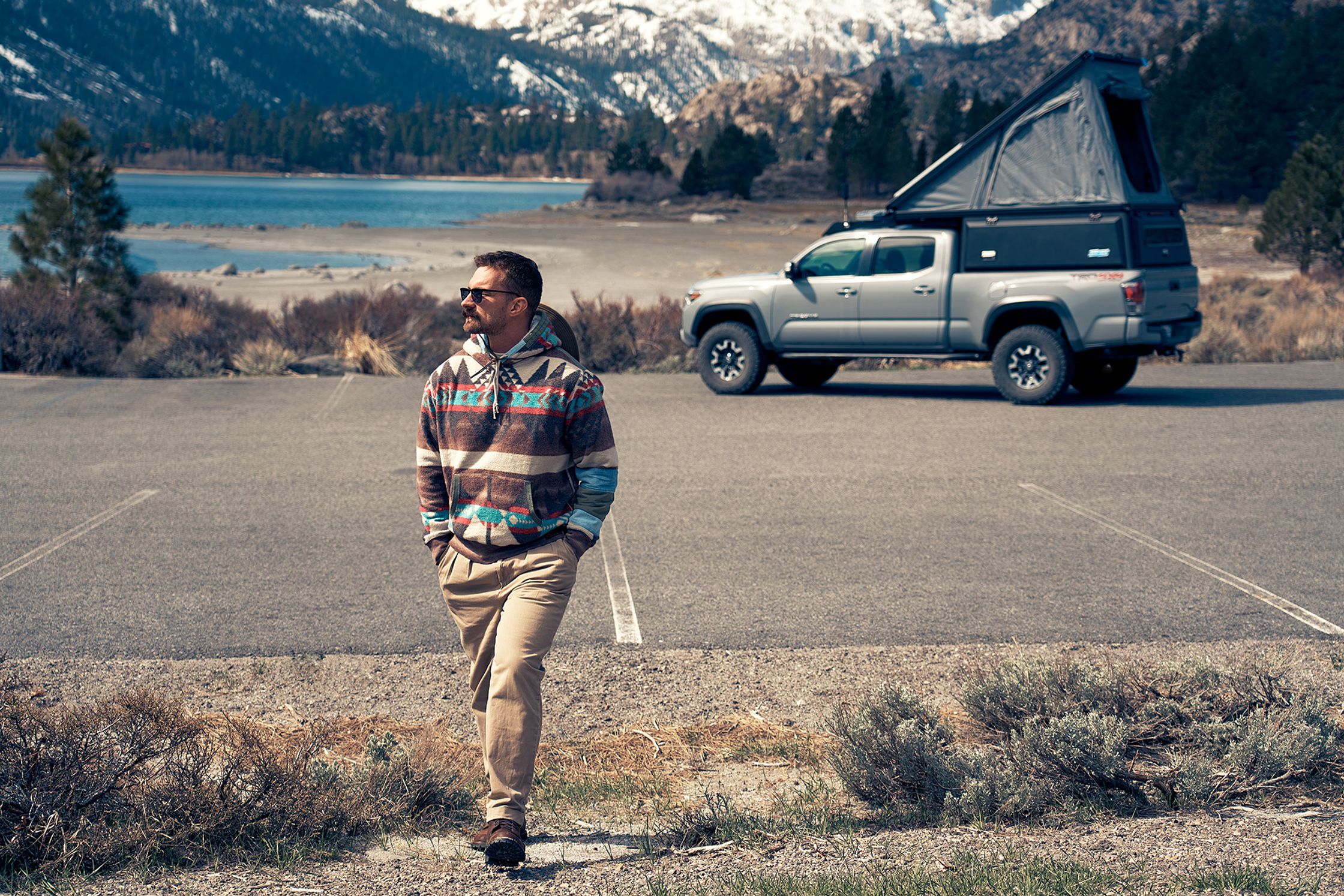 a man standing next to a truck in a parking lot