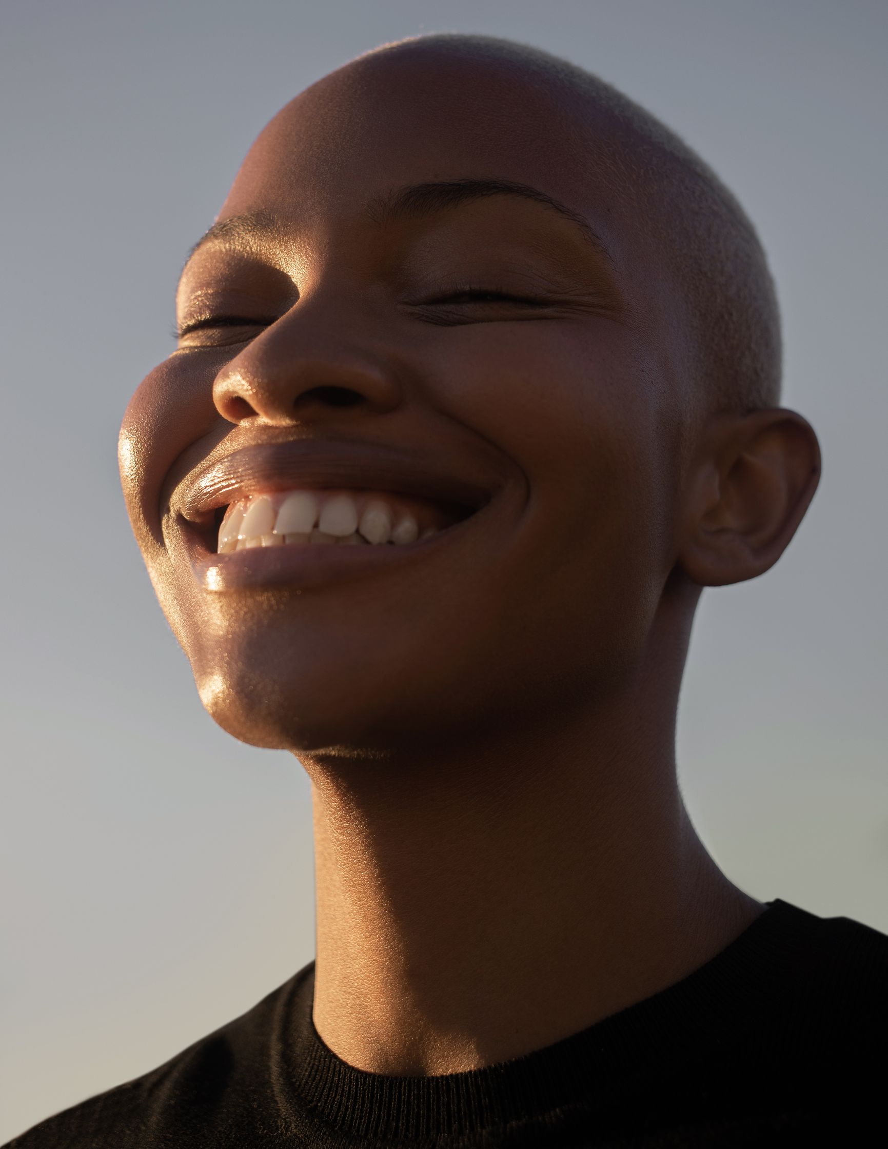 a woman with a shaved head is smiling