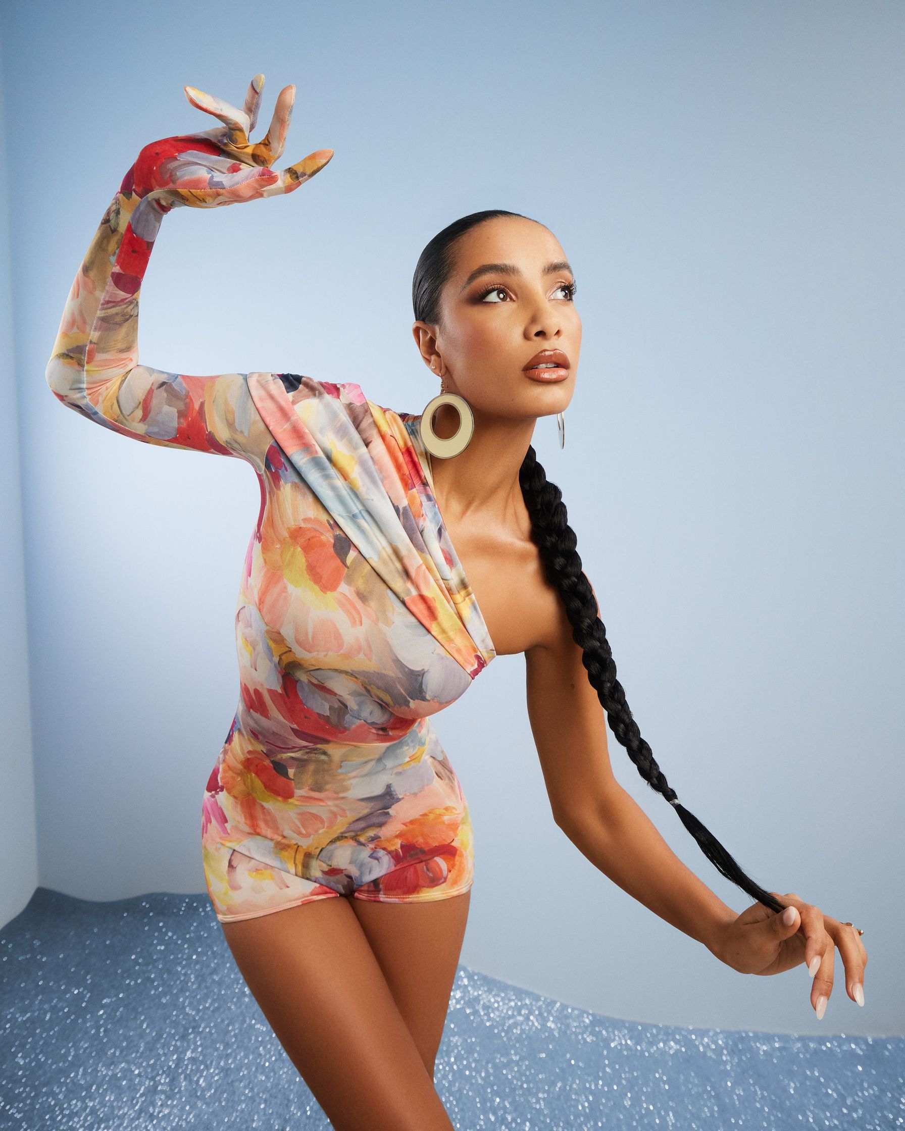 a woman in a floral dress posing with her arms outstretched