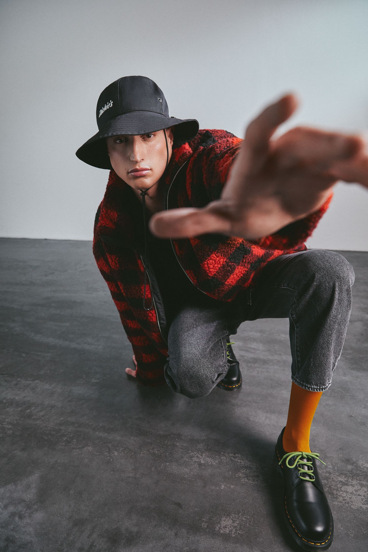 a man in a red and black plaid hat is posing for a photo