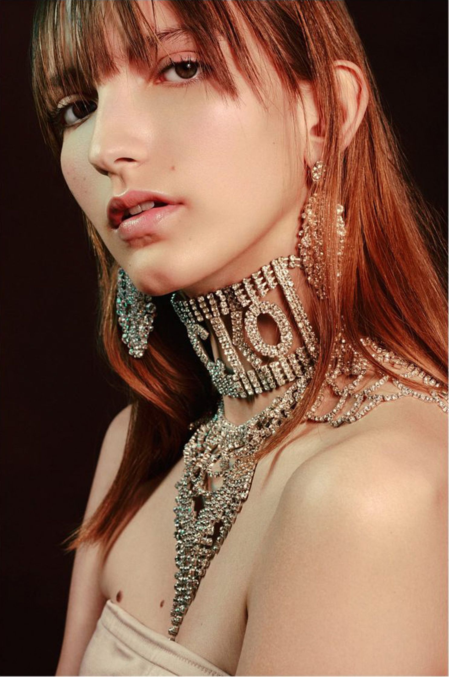 a woman in a silver choker posing for a magazine