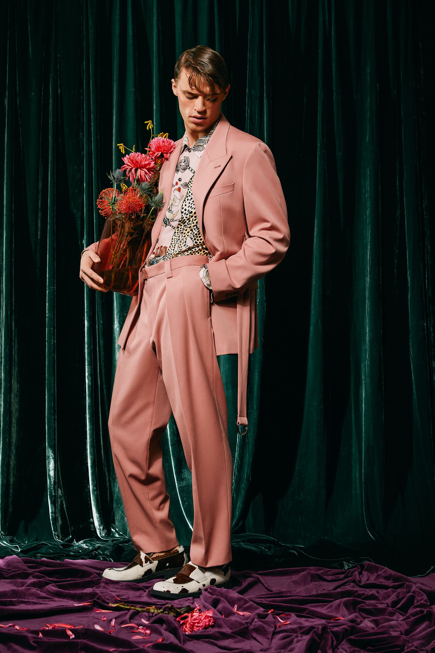 a man in a pink suit holding flowers