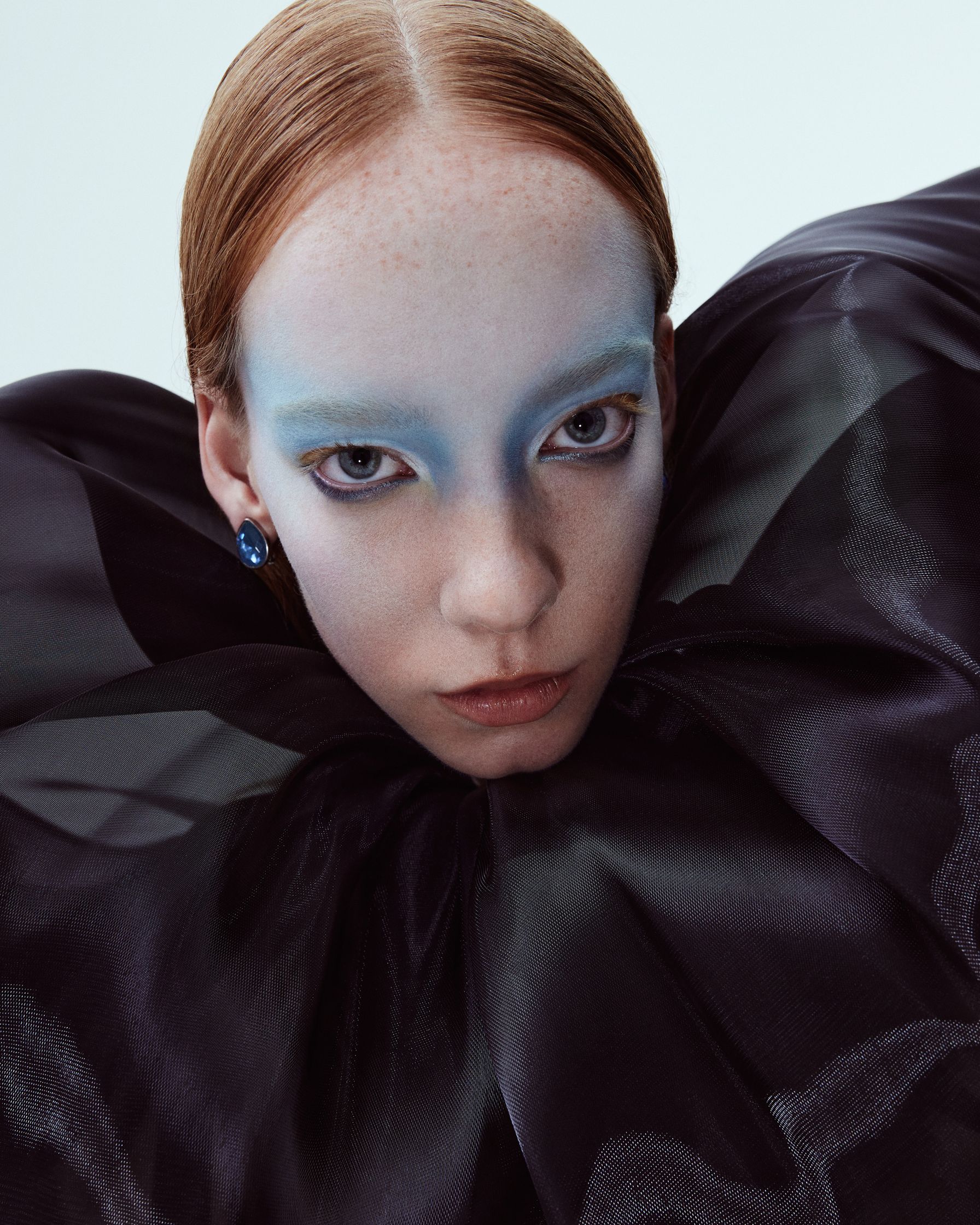 a woman in a black dress with blue eye makeup