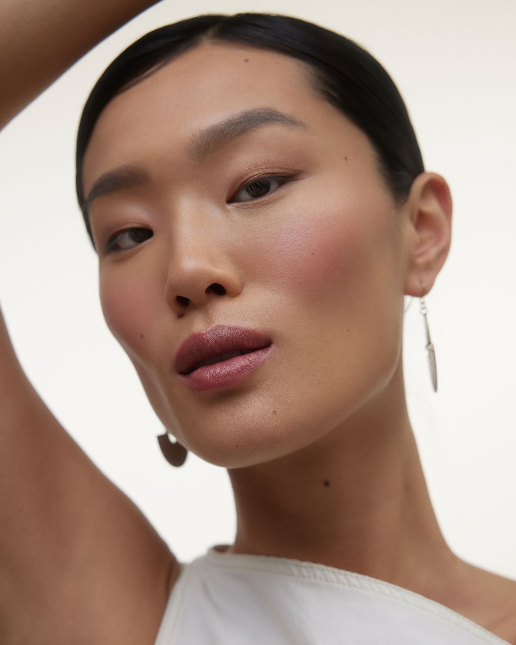 a woman is posing for a photo in a white top