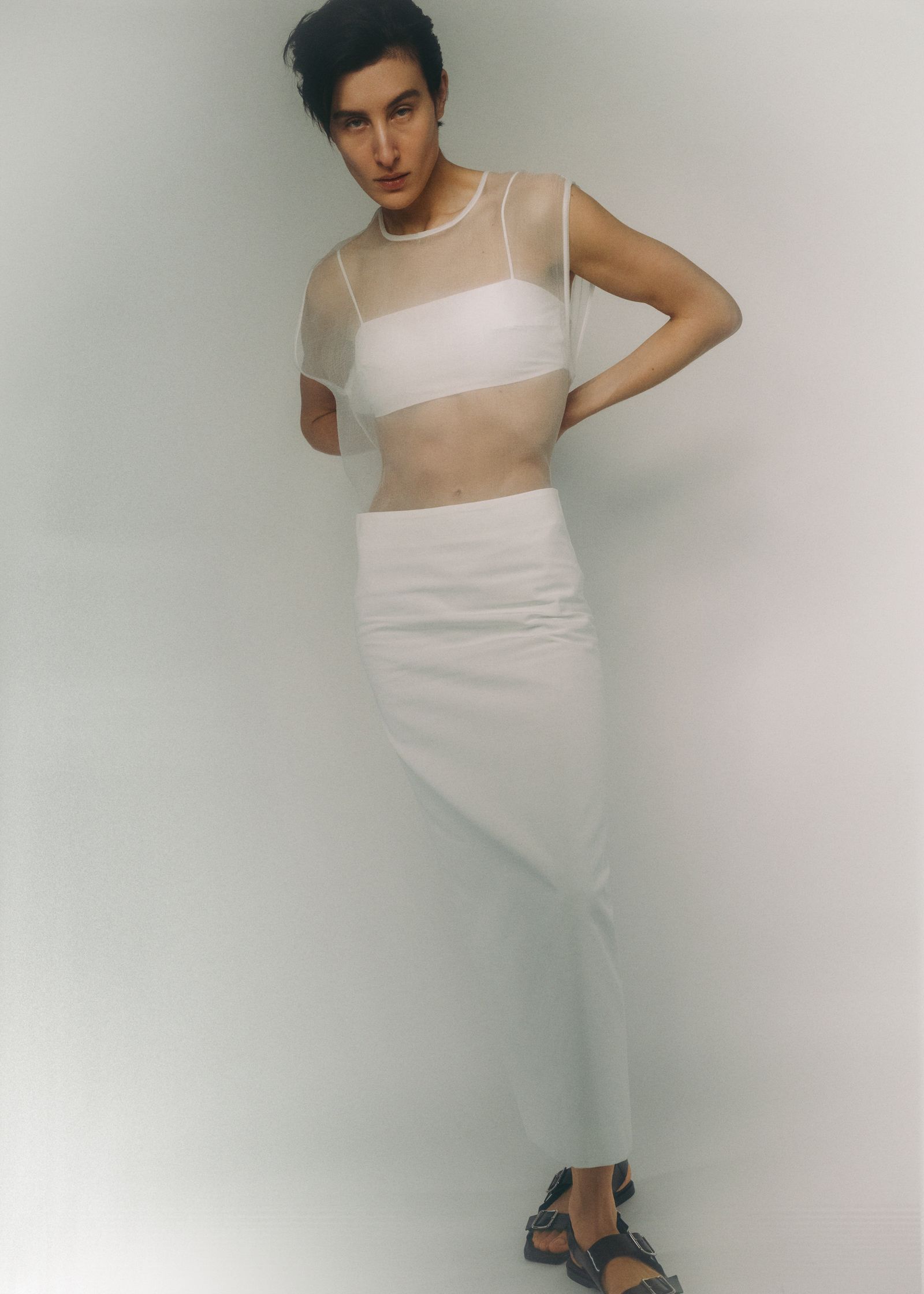 a woman posing in a white skirt and top