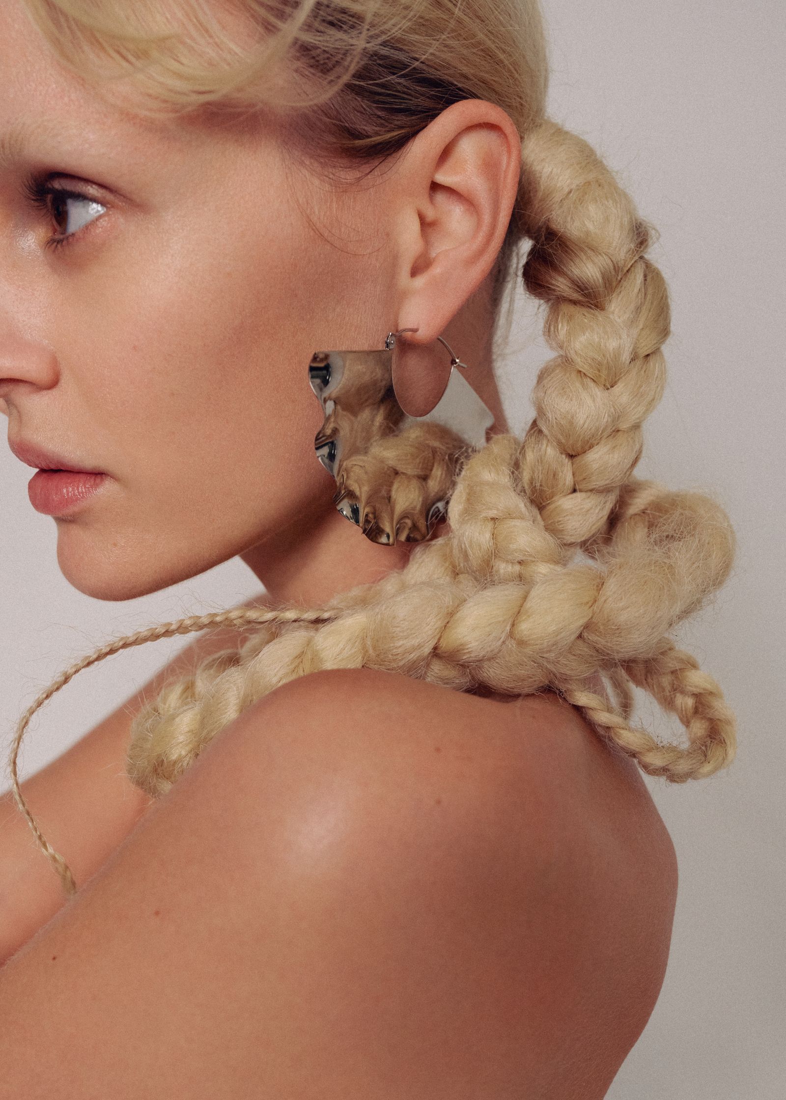 a blonde woman with braided hair is posing for a photo