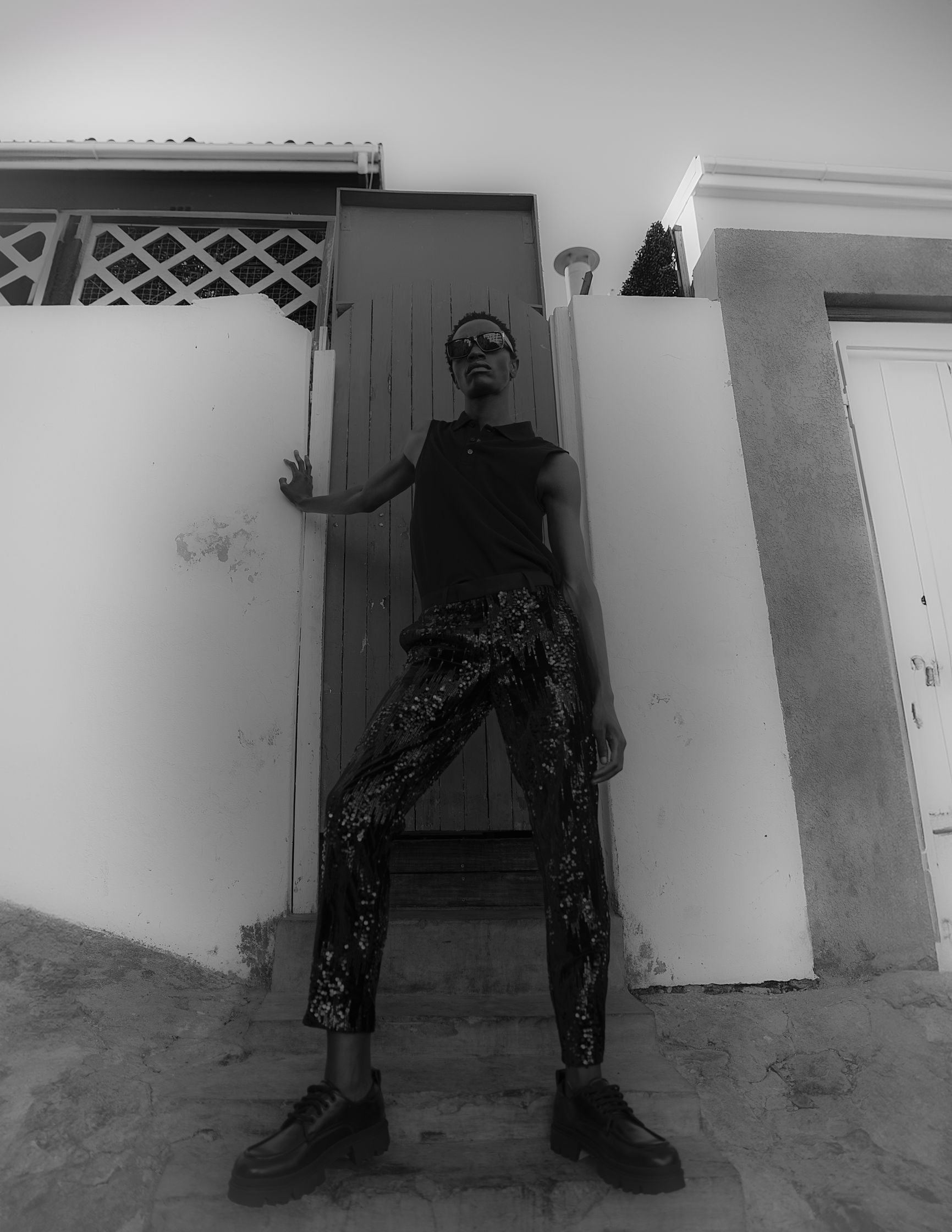a black and white photo of a man leaning against a wall