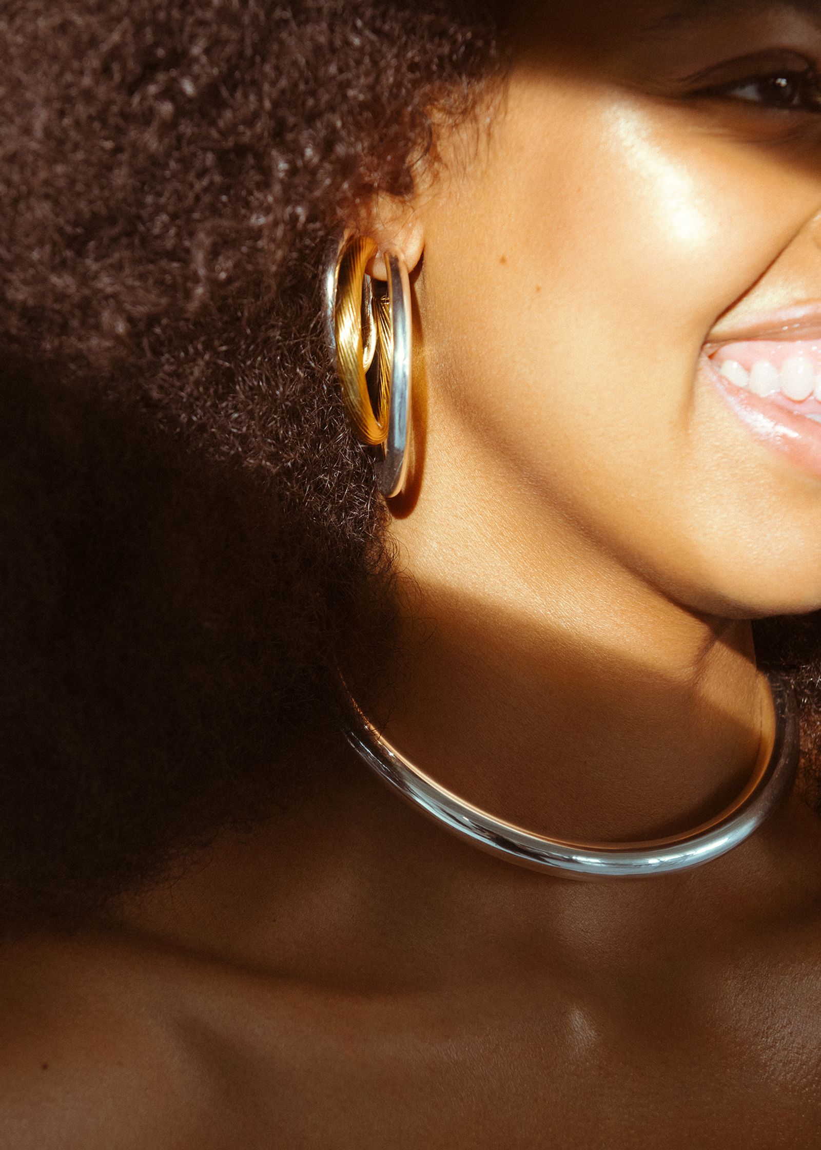 a woman with afro hair and gold hoop earrings