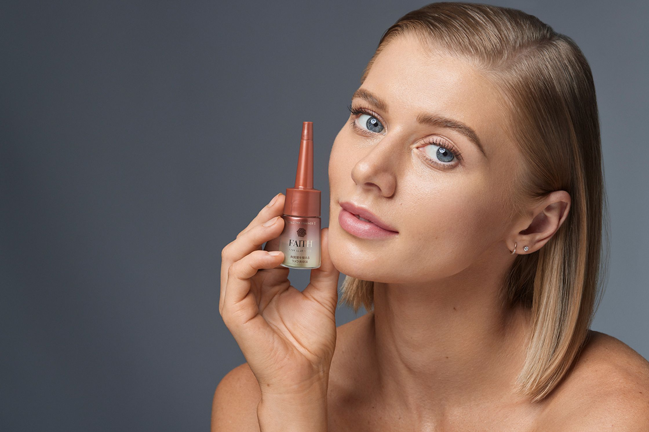 a woman is holding a bottle of makeup on her face