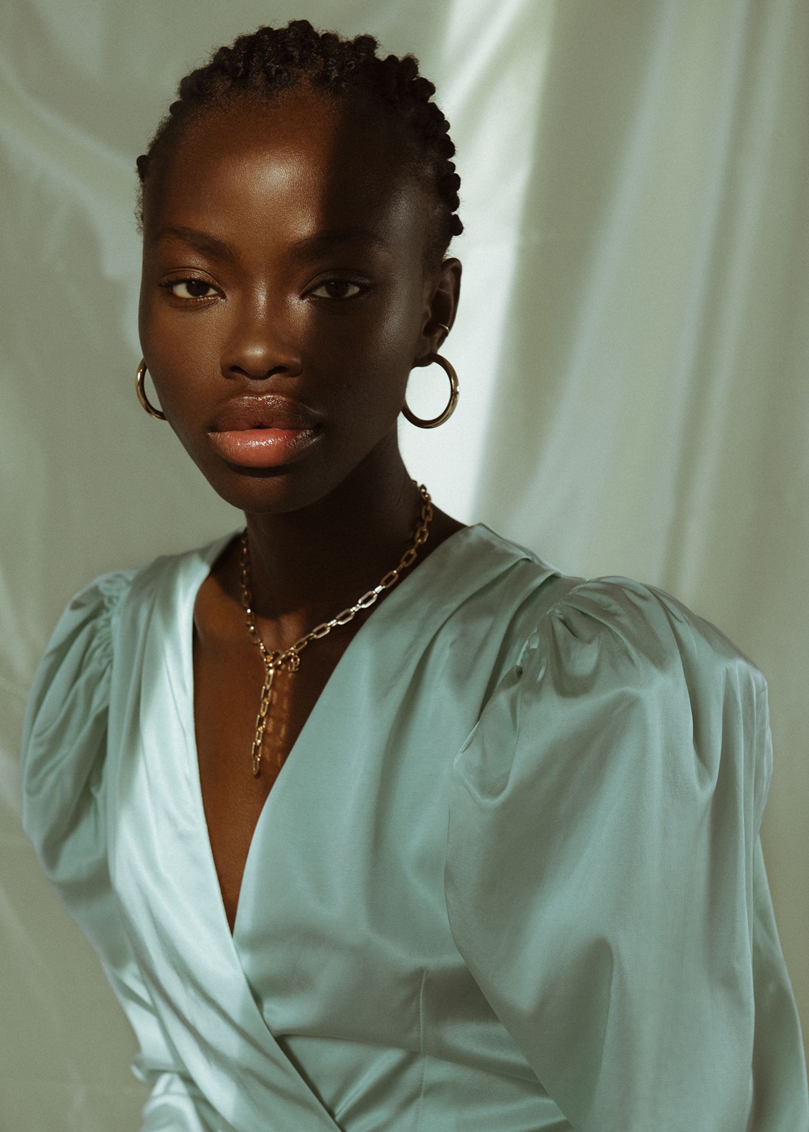 a black woman in a light blue dress posing for a photo