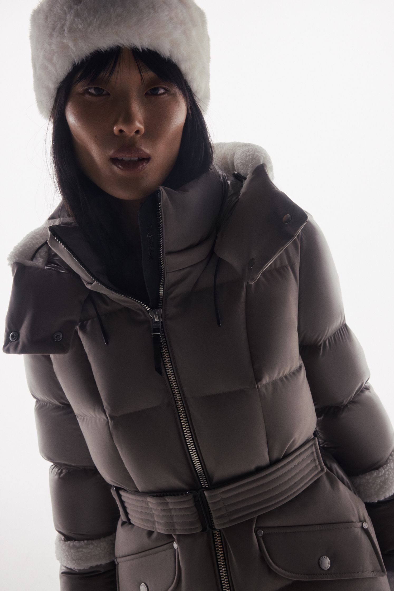 a woman wearing a grey puffer jacket and hat