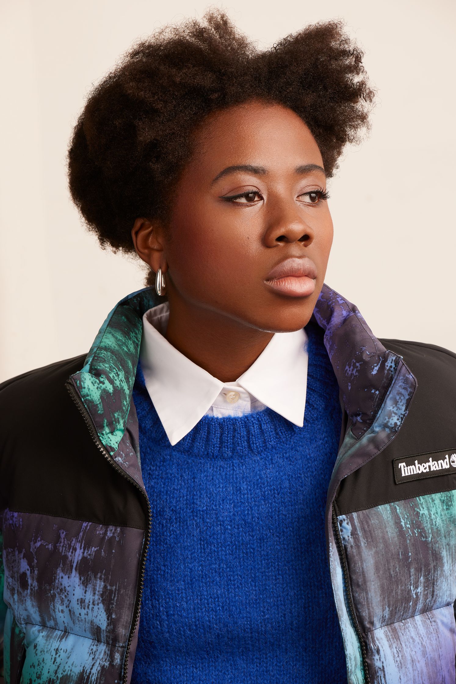 a black woman wearing a colorful jacket