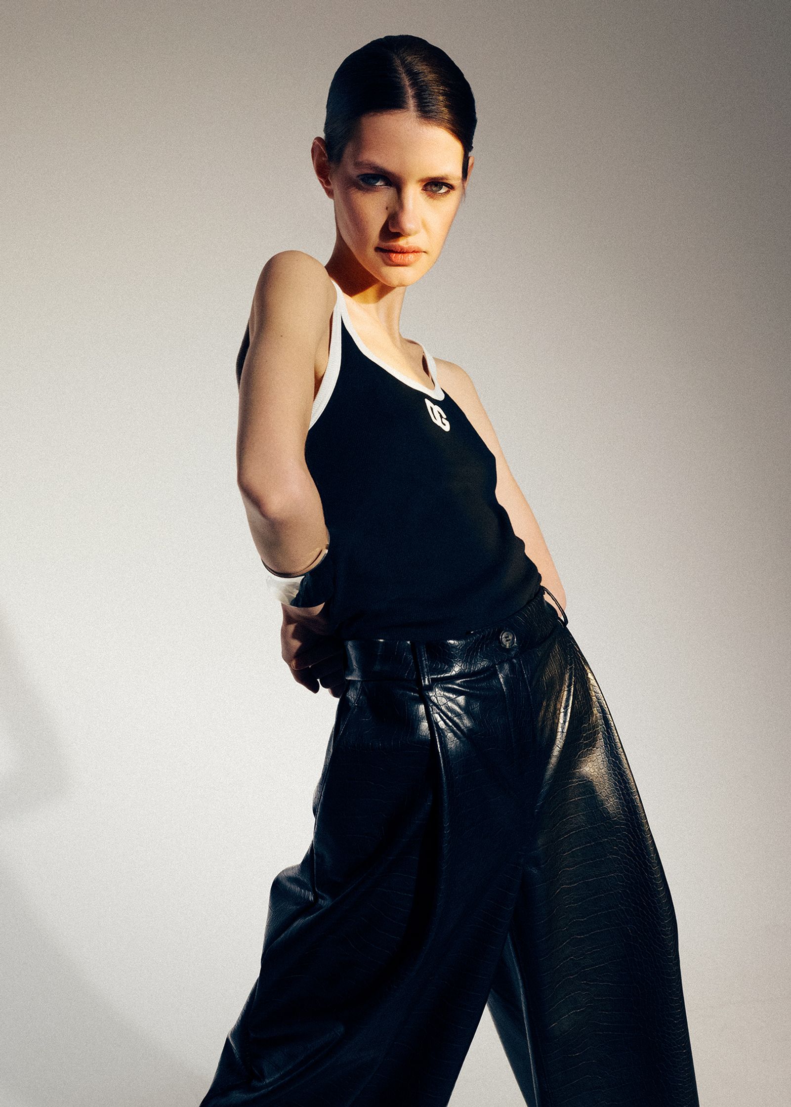 a woman in black leather pants posing for a photo shoot