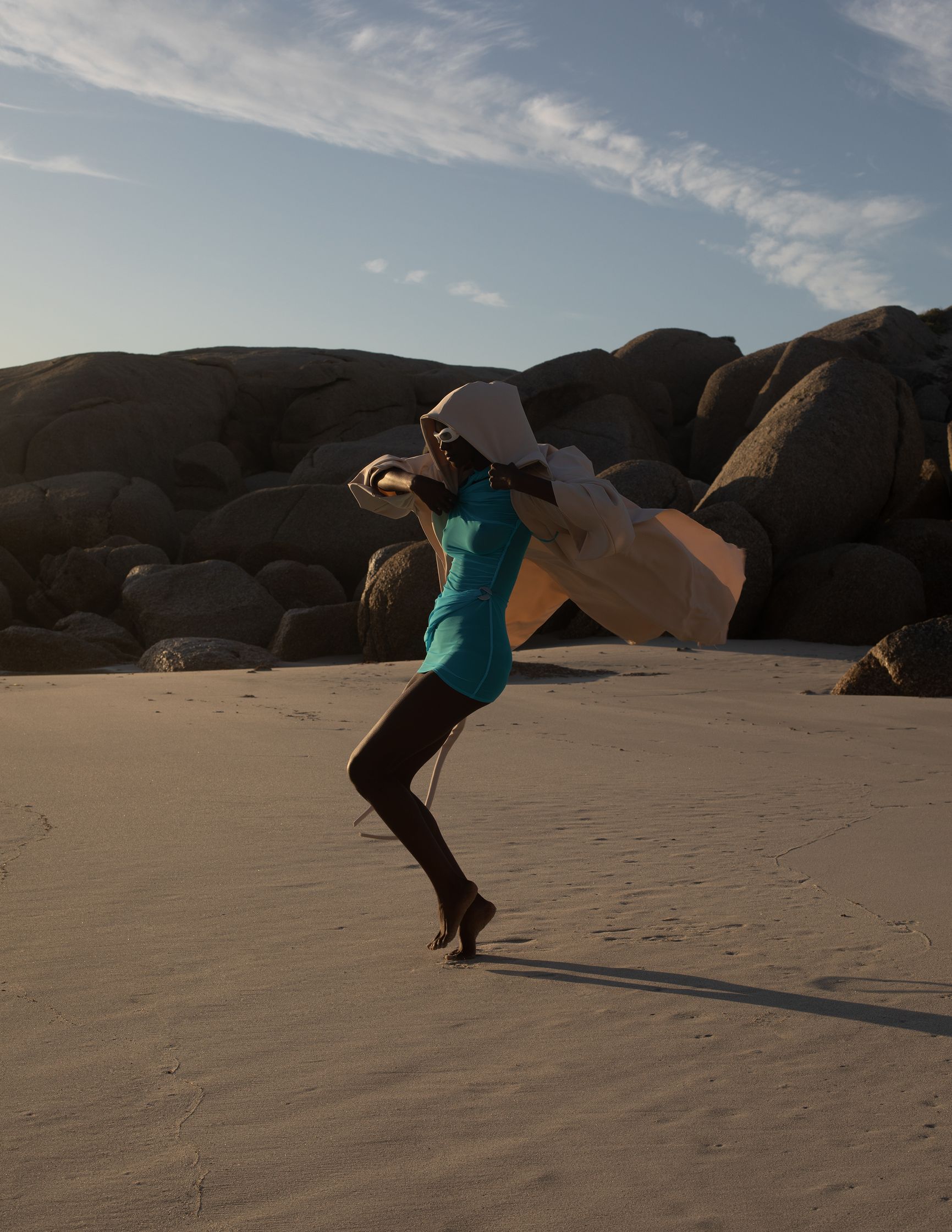 a woman is flying a kite on a beach