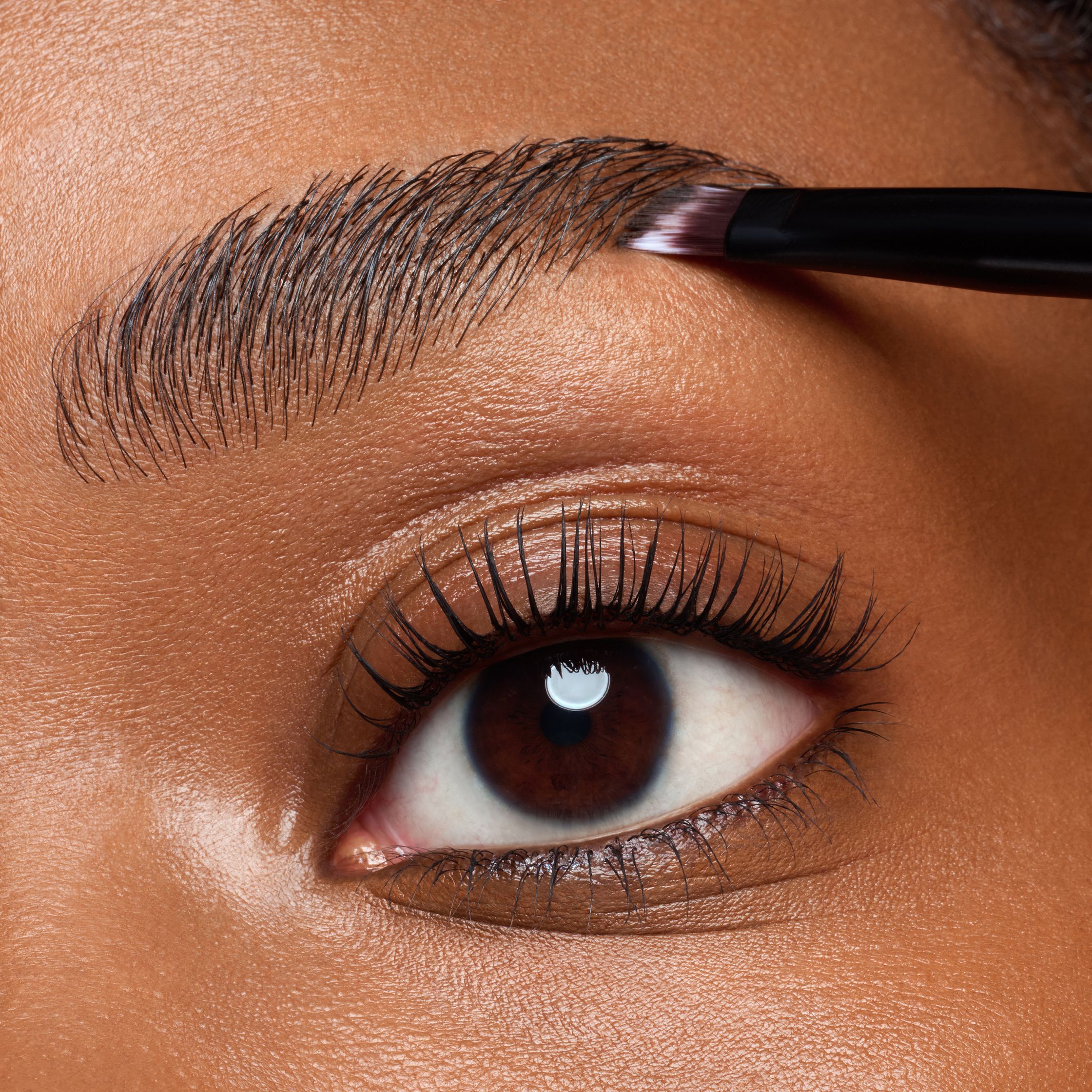 a close up of a woman's eyebrows with a brush