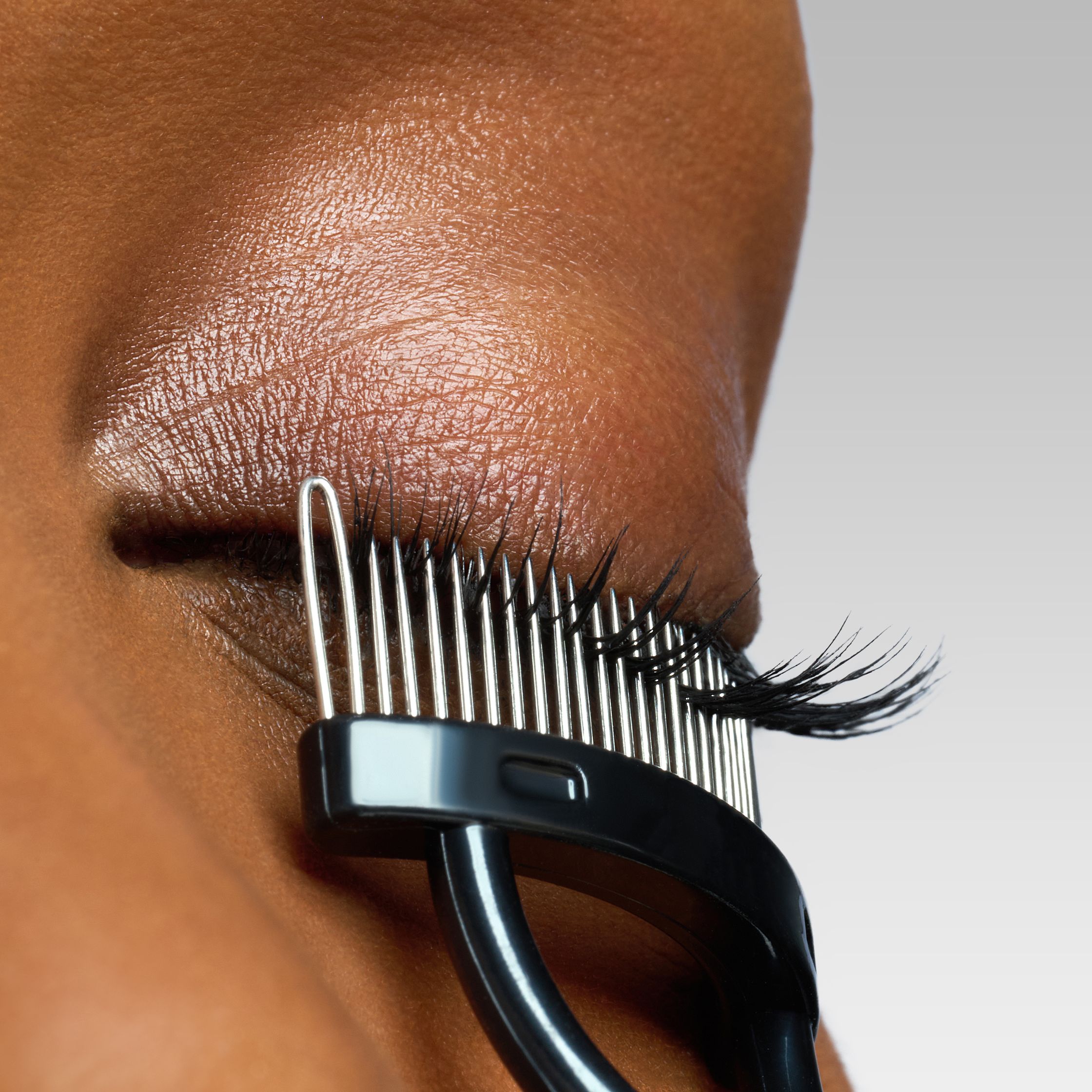 a close up of a woman's eye with a pair of eyelash combs