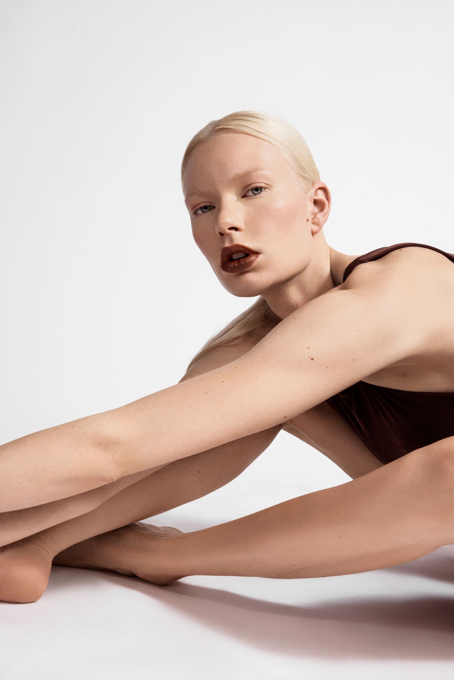 a woman posing on the floor with her legs stretched out