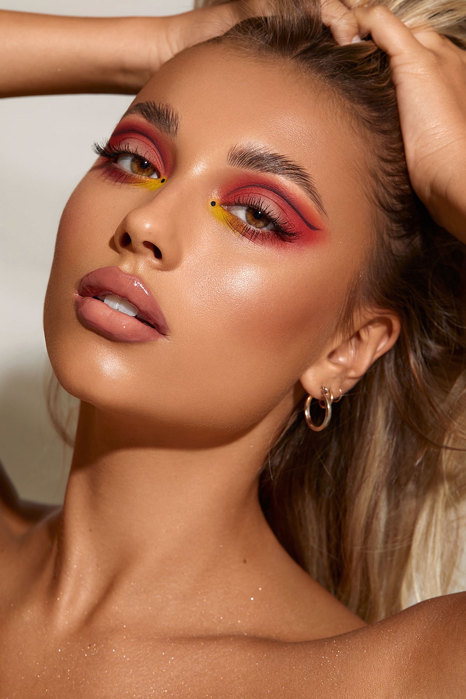 a model wearing red makeup and posing for a photo