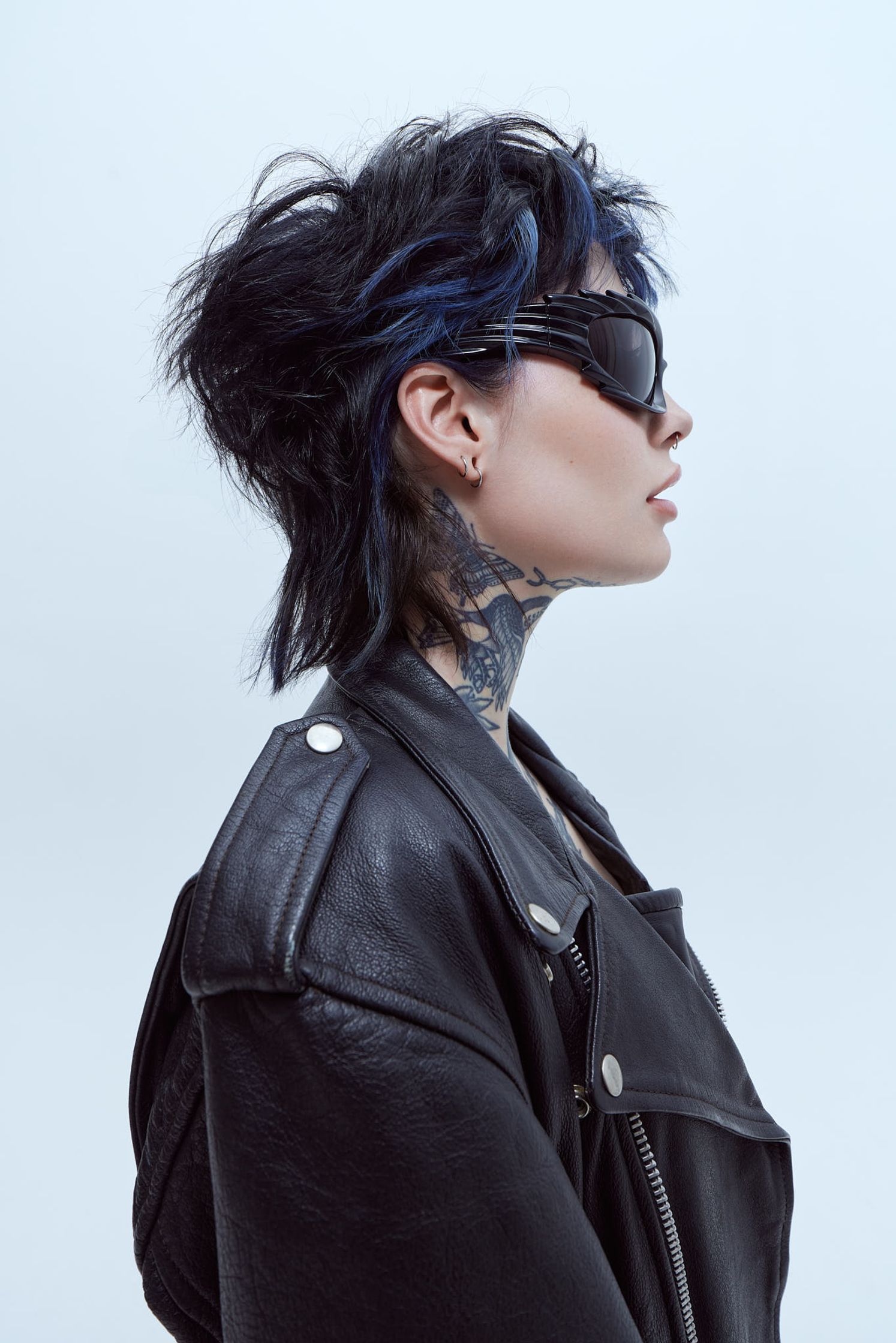 a woman in a black leather jacket with blue tattoos