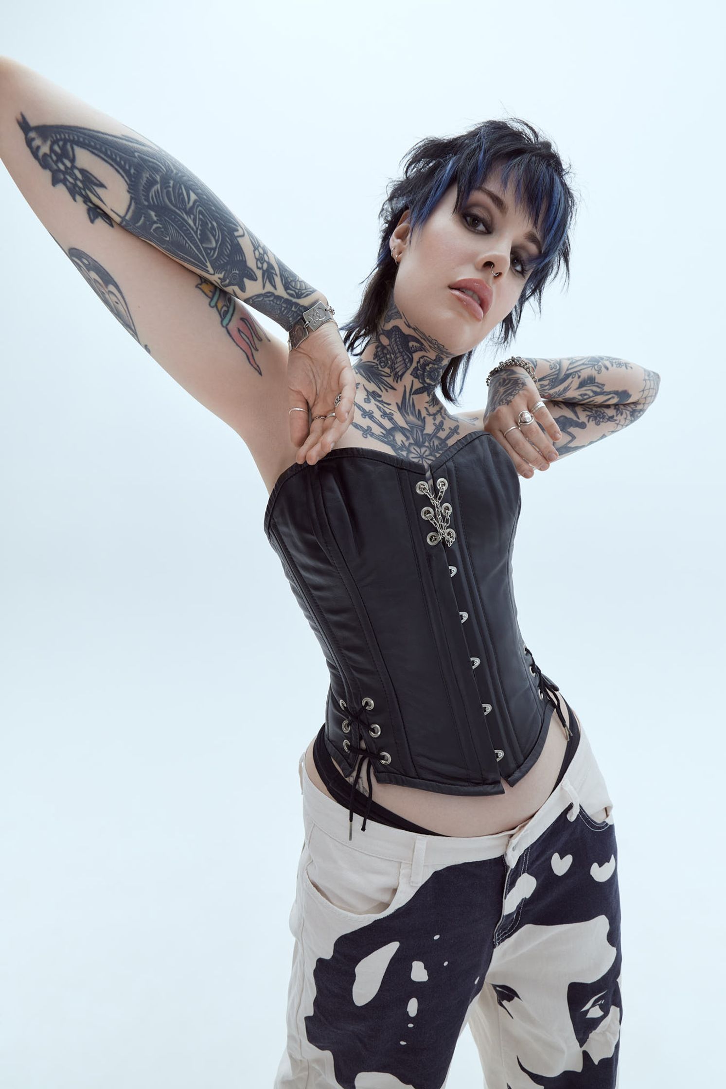 a woman with tattoos posing in a corset