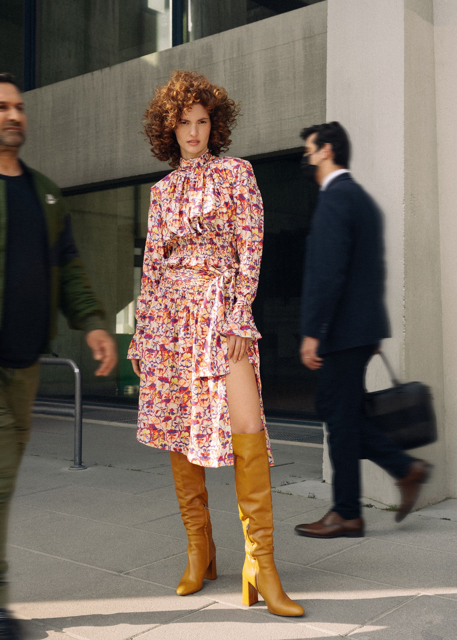 a woman wearing a floral dress and thigh high boots