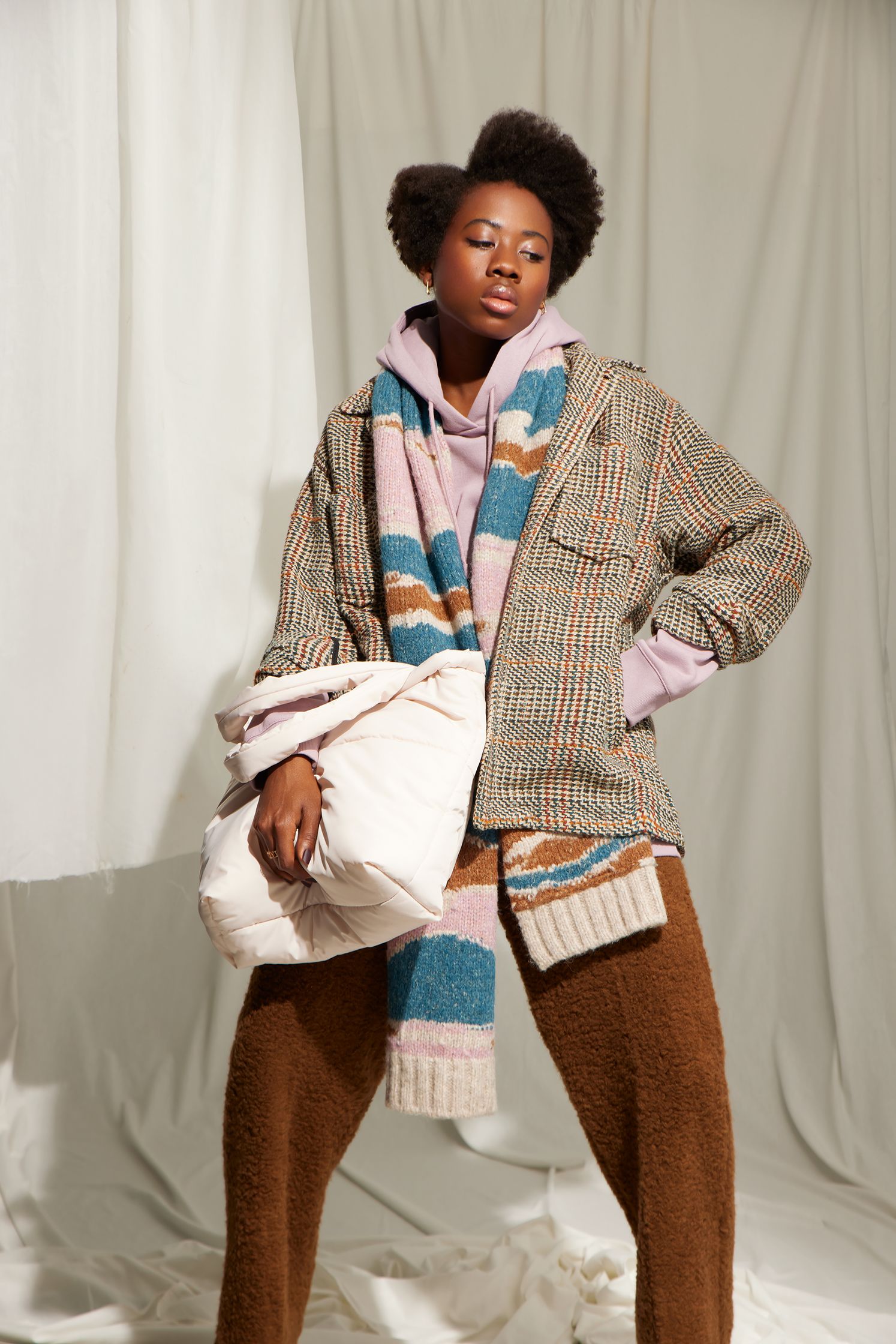 a black woman in a plaid coat and scarf posing for a photo