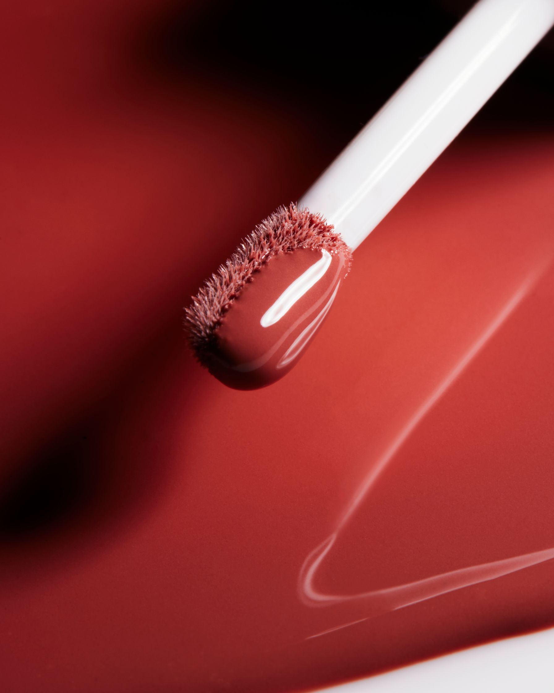a close up of a lipstick on a red surface