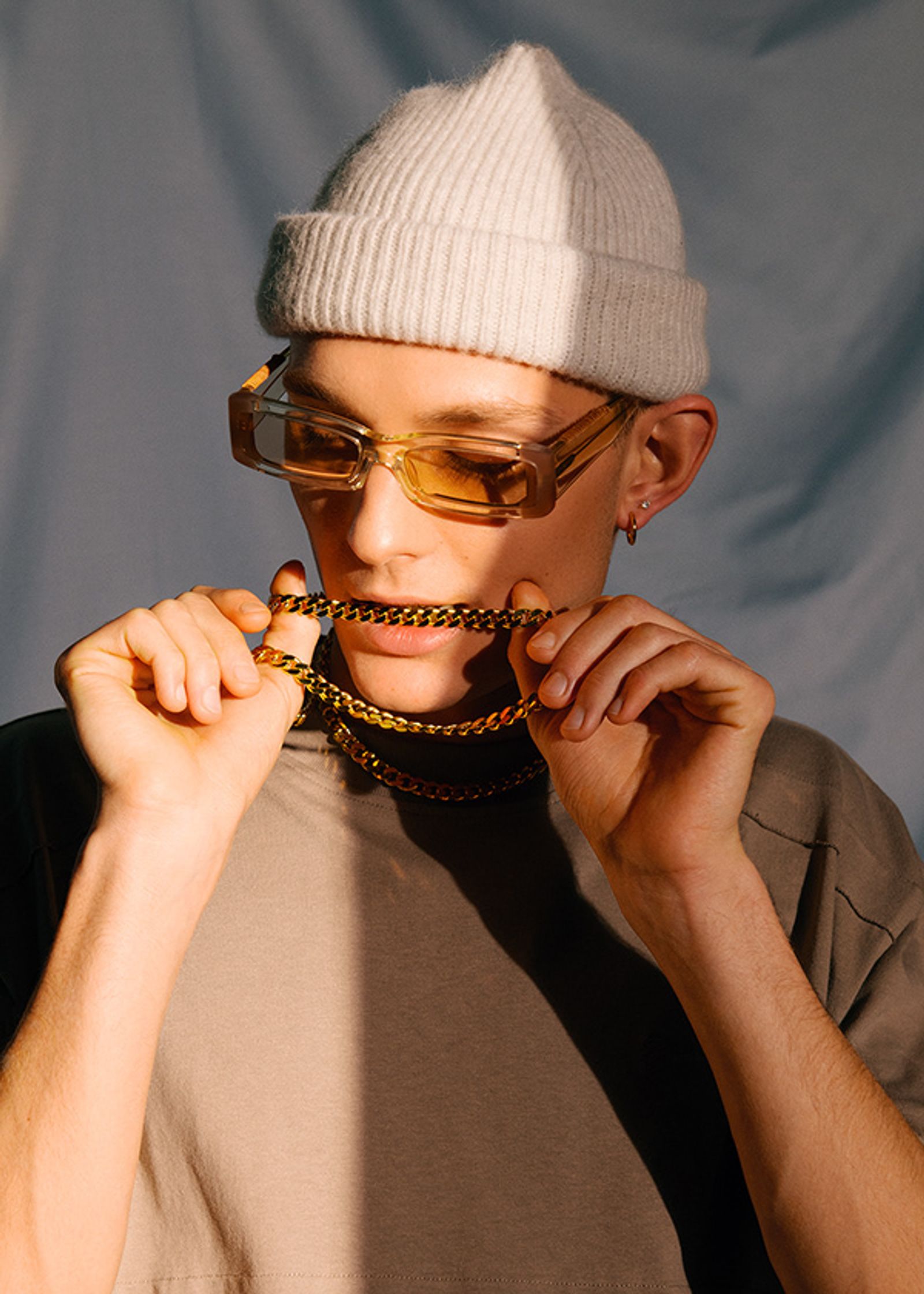 a man wearing a beanie and a necklace