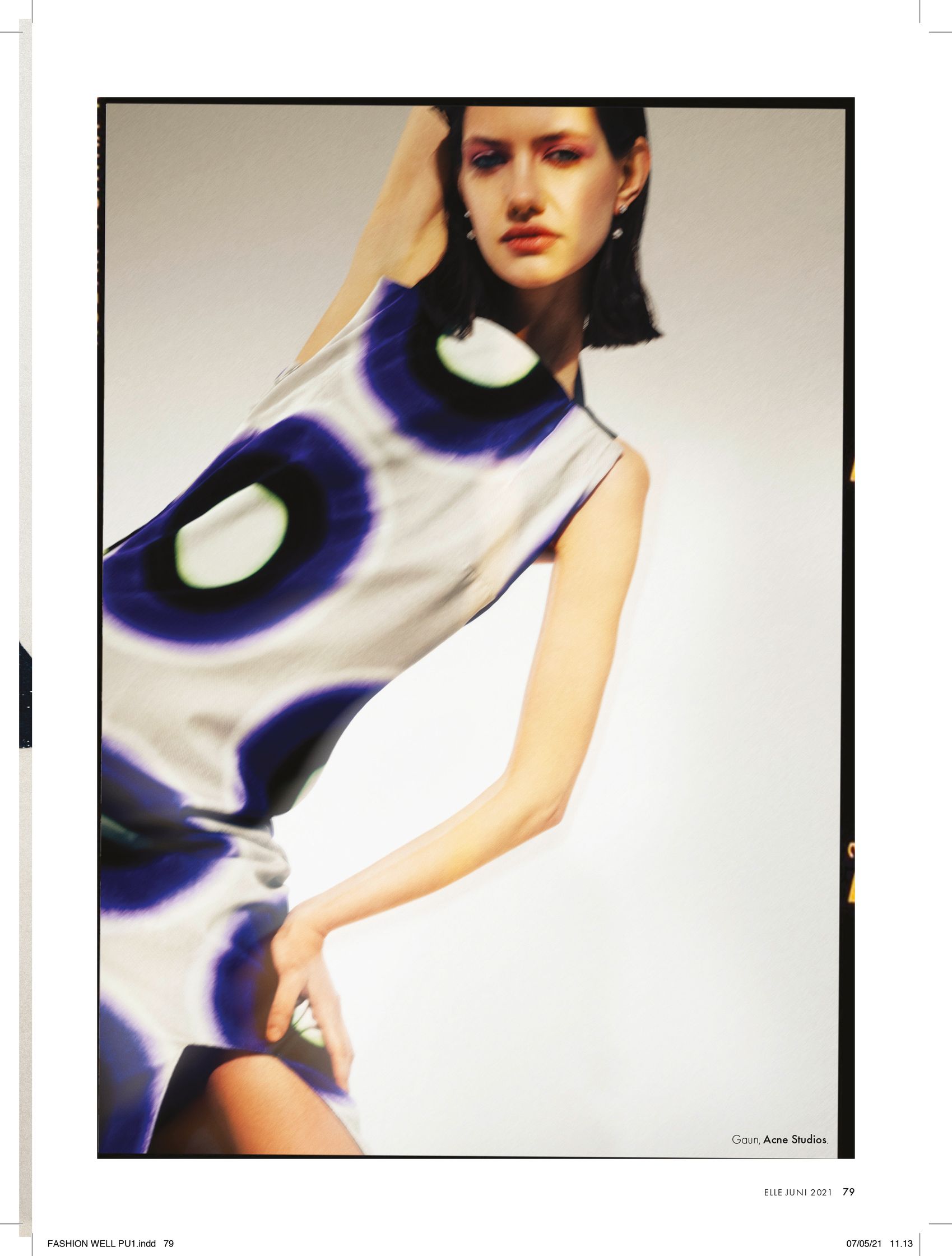 a woman is posing in a blue and white dress