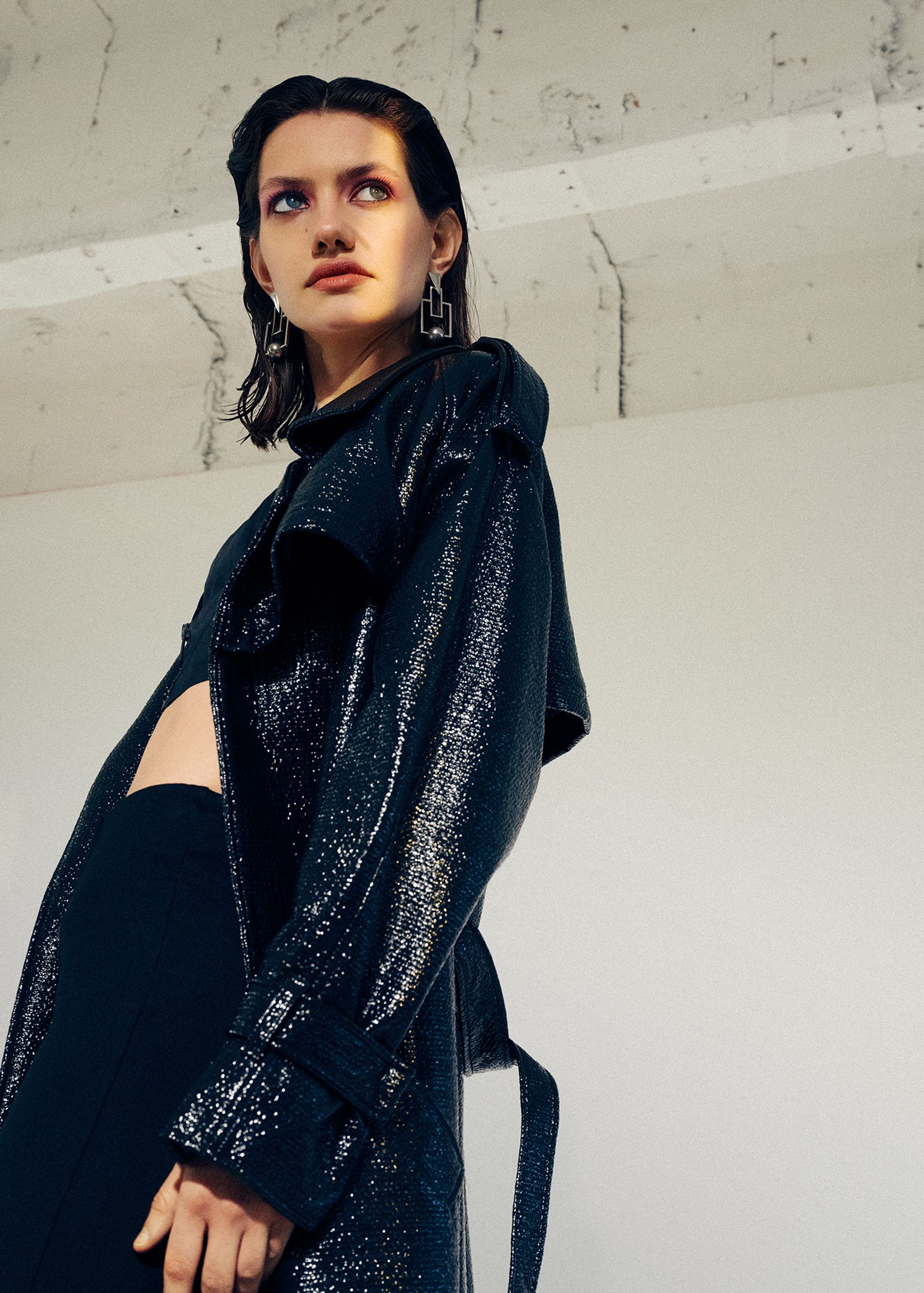 a model wearing a black trench coat
