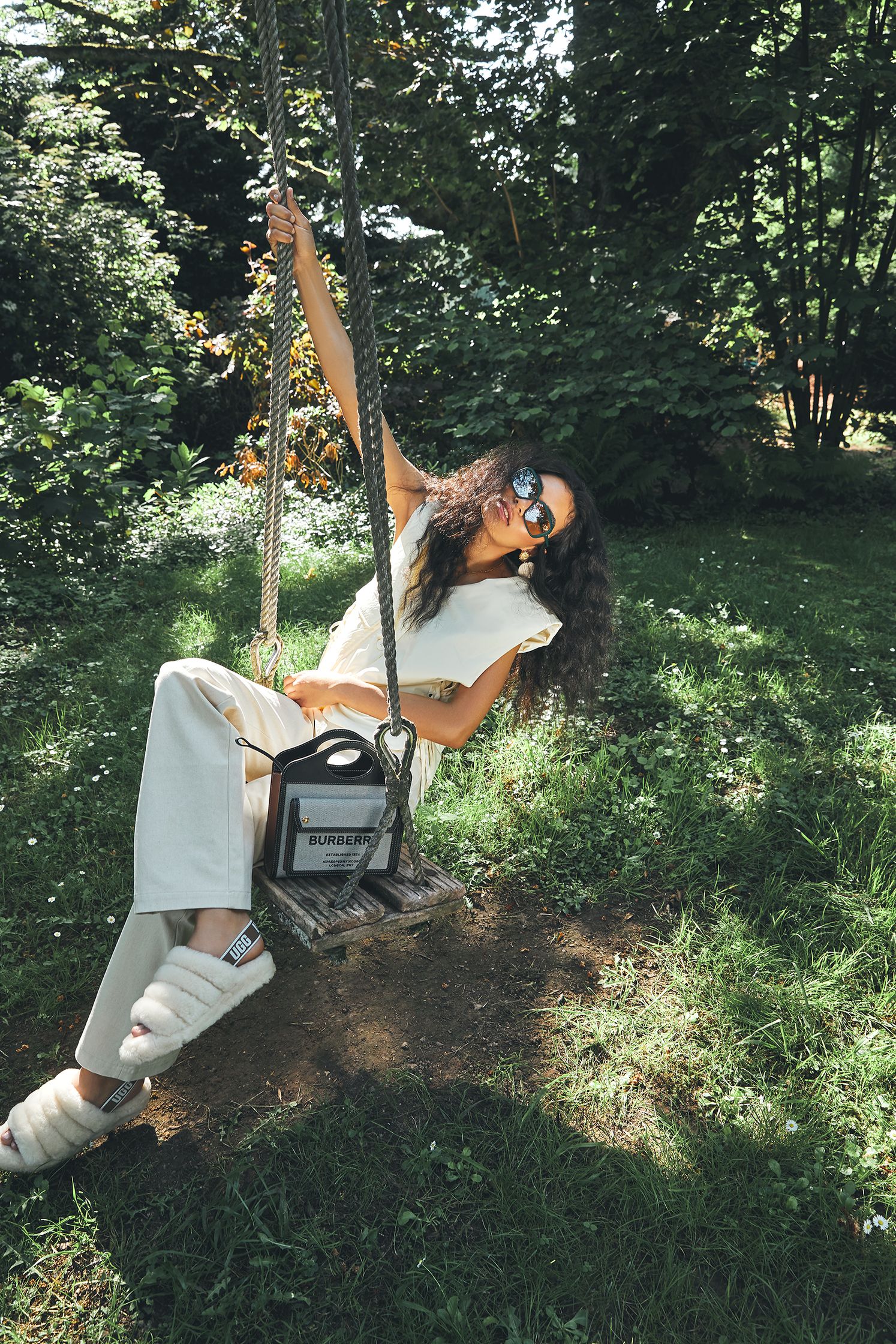 a woman sitting on a swing in a park