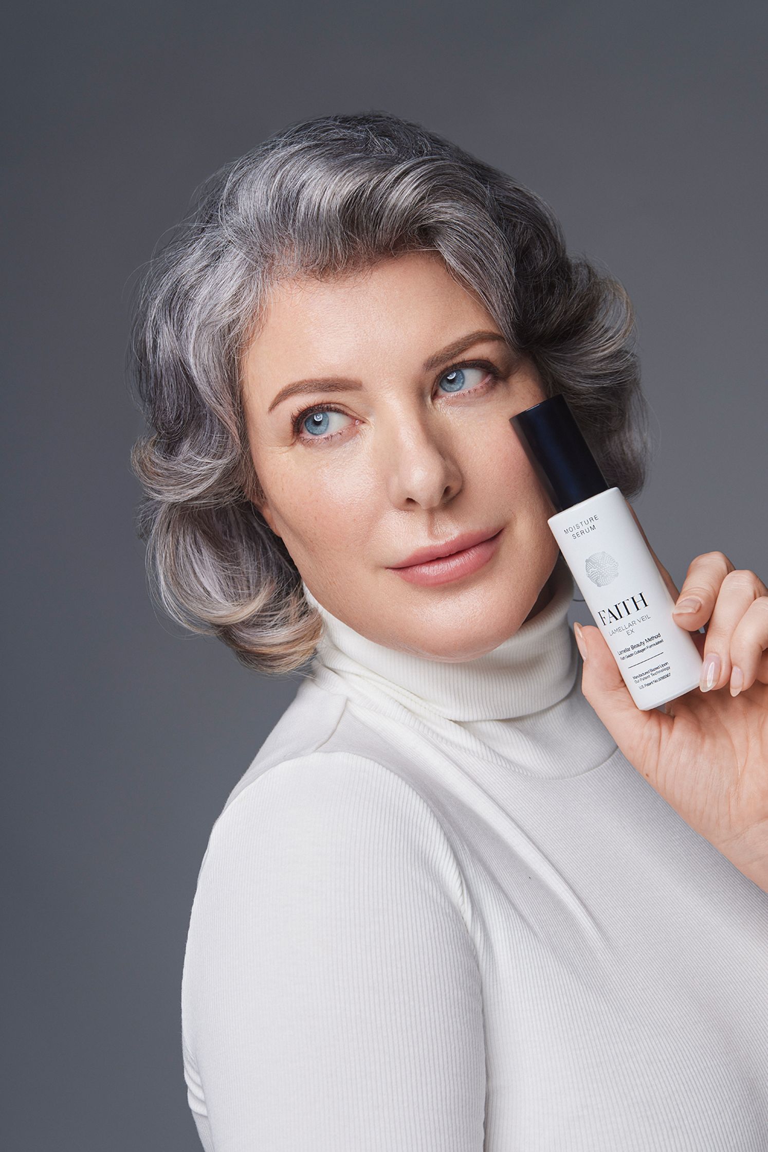 a woman holding a bottle of anti - aging cream