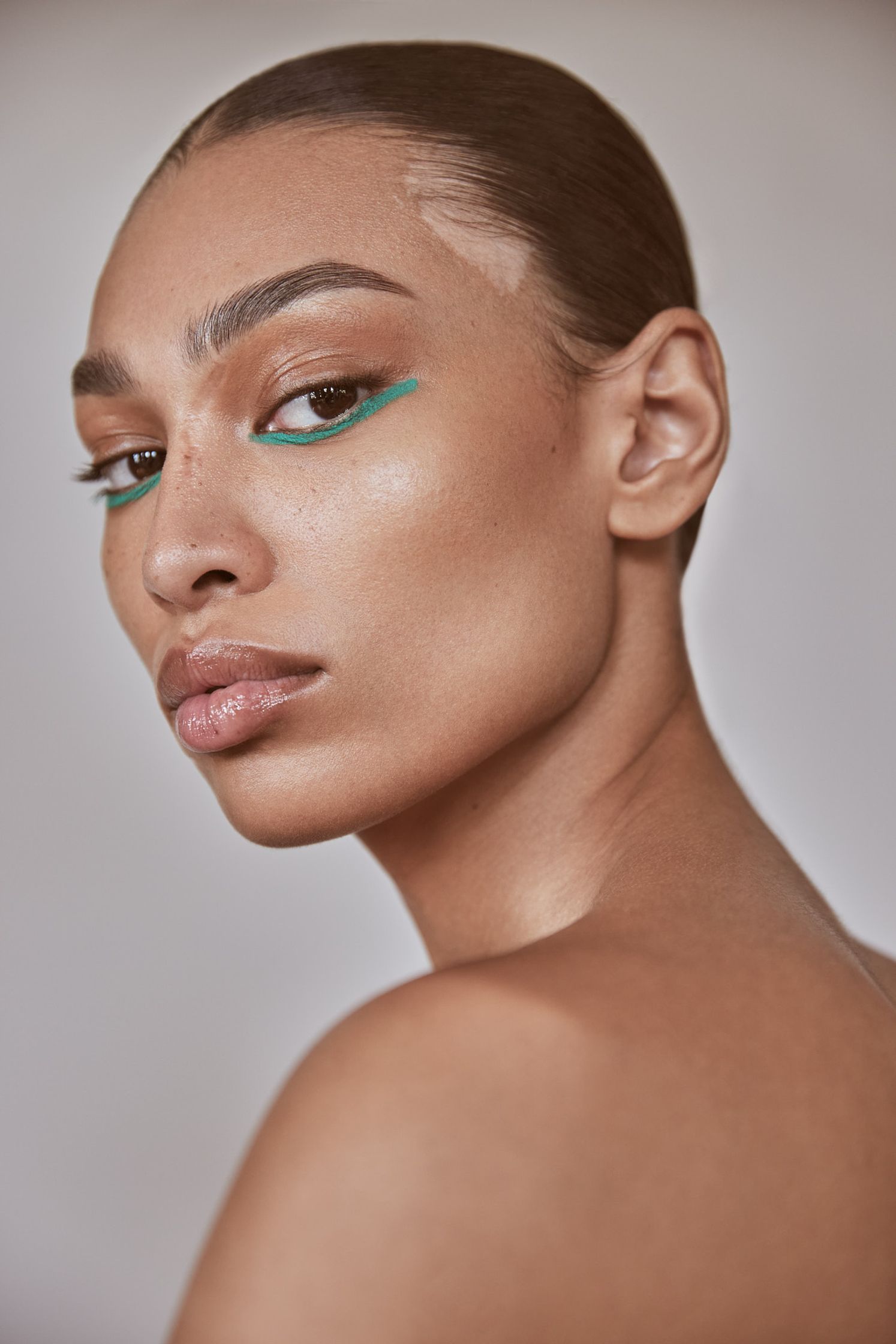 a woman with green eyeliner posing for a photo shoot