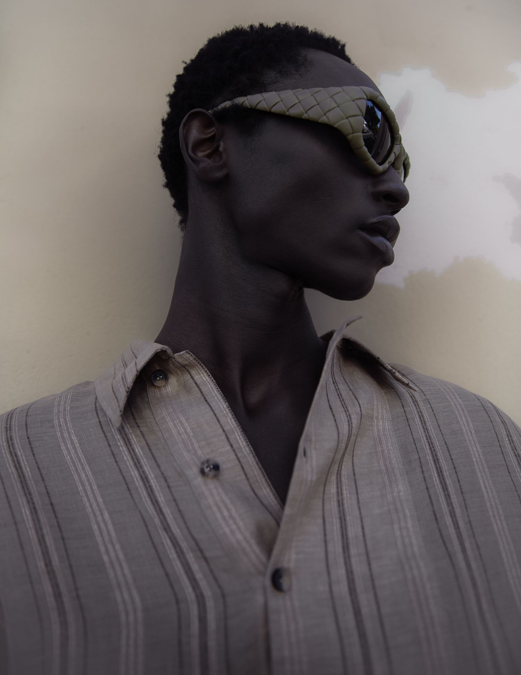 a black man wearing sunglasses and a striped shirt
