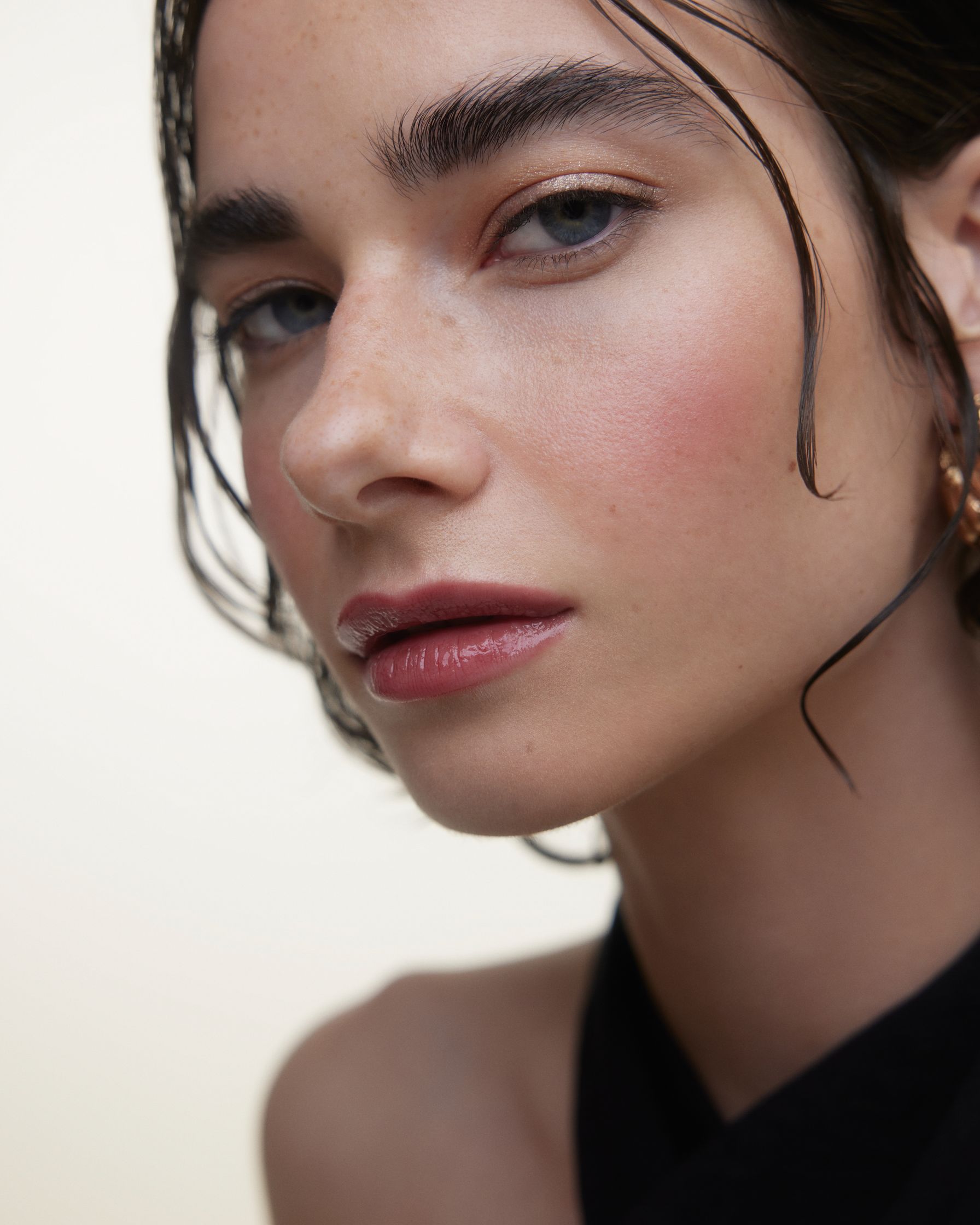 a woman with wet hair and earrings is posing for a photo