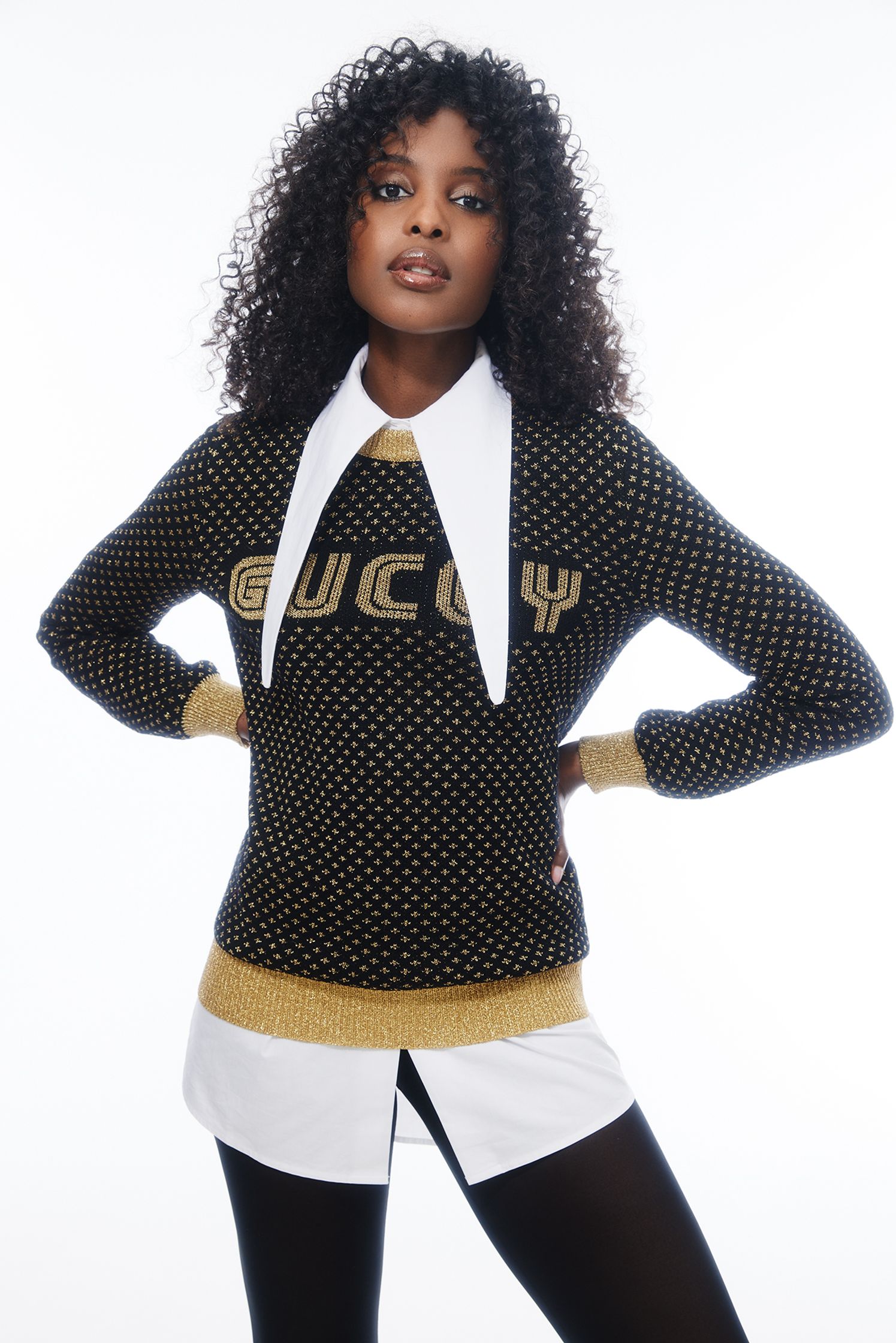 a woman in a black sweater and tights posing for a photo